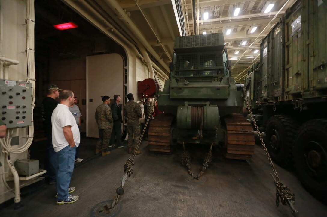 PACIFIC OCEAN (Dec. 9, 2015) U.S. Marines with Combat Logistic Battalion 15, 15th Marine Expeditionary Unit display the Dozer-MCT (Medium Crawl Tractor) to family members aboard the USS Anchorage (LPD 23). The 15th MEU is coming to the end of deployment and hosting a Tigers Cruise for family members to showcase life aboard the Anchorage. (U.S. Marine Corps photo by Sgt. Steve H. Lopez/Released)