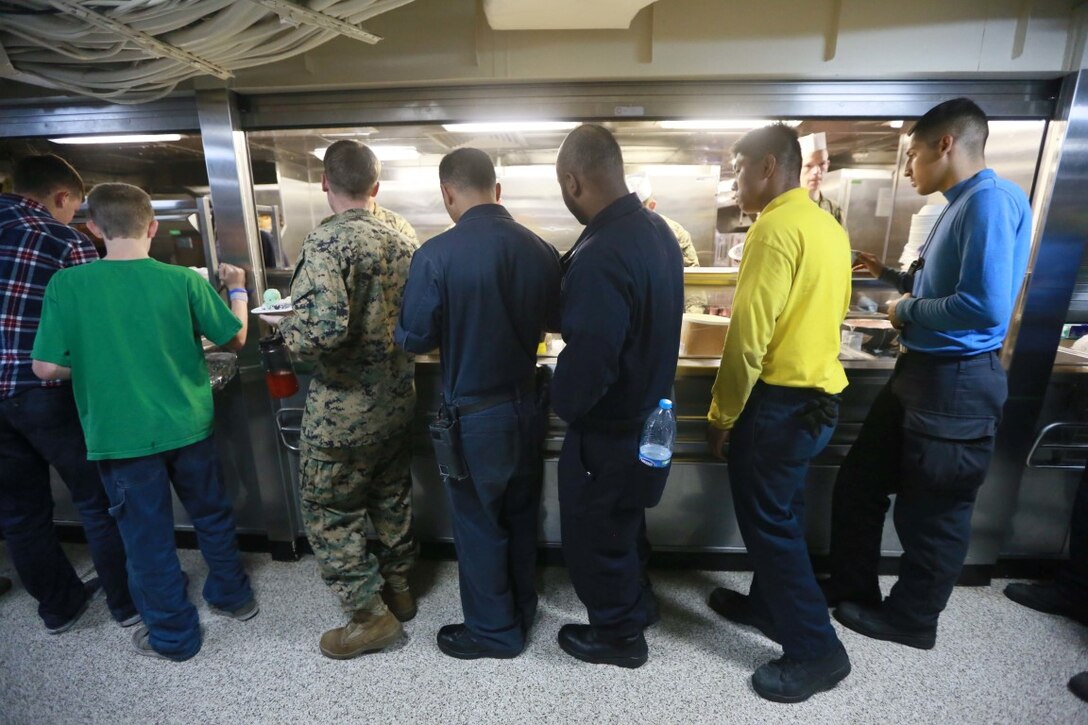 PACIFIC OCEAN (Dec. 9, 2015) U.S. Marines and Sailors with the 15th Marine Expeditionary Unit and USS Anchorage (LPD 23) and family members stand in line for ice cream during an ice cream social enjoy aboard the Anchorage. The 15th MEU is coming to the end of deployment and hosting a Tiger Cruise for family members to showcase life aboard the Anchorage. (U.S. Marine Corps photo by Sgt. Steve H. Lopez/Released)