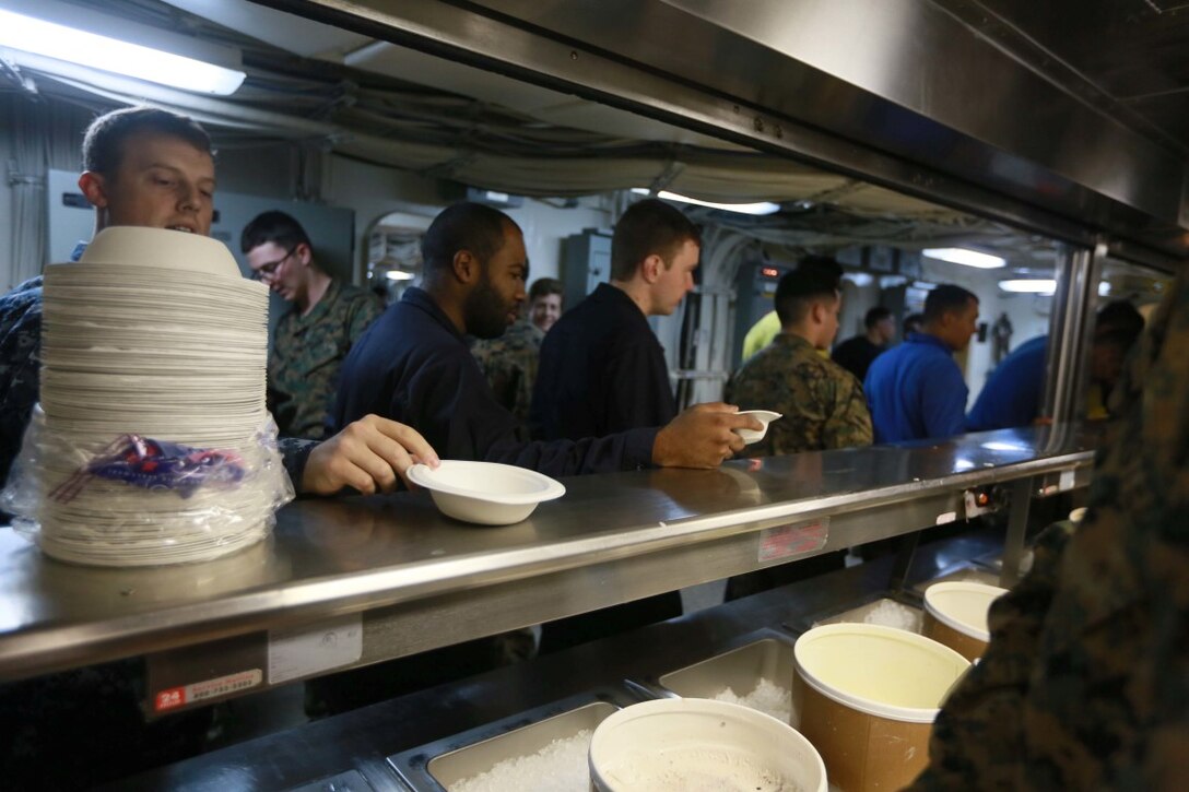 PACIFIC OCEAN (Dec. 9, 2015) U.S. Marines and Sailors with the 15th Marine Expeditionary Unit, USS Anchorage (LPD 23), and family members stand in line for ice cream during an ice cream social aboard the Anchorage. The 15th MEU is coming to the end of deployment and hosting a Tiger Cruise for family members to showcase life aboard the Anchorage. (U.S. Marine Corps photo by Sgt. Steve H. Lopez/Released)