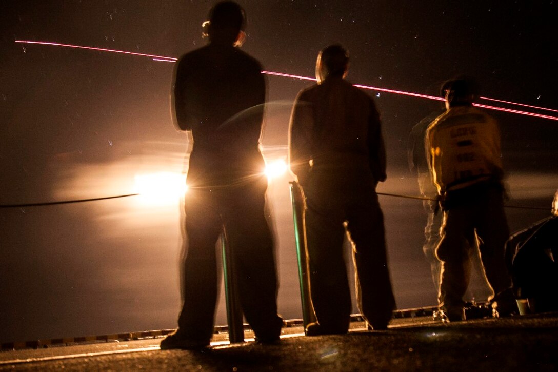 PACIFIC OCEAN (Dec. 9, 2015) U.S. Marines with the 15th Marine Expeditionary Unit and Sailors with the Essex Amphibious Ready Group watch a 'fireworks' weapons display with the family members on the flight deck of amphibious assault ship USS Essex (LHD 2). The family members are on a Tiger Cruise from Hawaii back to California to experience the day-to-day life of their Marines and Sailors. (U.S. Marine Corps photo by Sgt. Elize McKelvey/Released