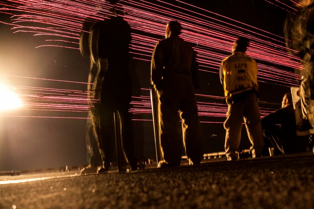 PACIFIC OCEAN (Dec. 9, 2015) U.S. Marines with the 15th Marine Expeditionary Unit and Sailors with the Essex Amphibious Ready Group watch a 'fireworks' weapons display with their family members on the flight deck of amphibious assault ship USS Essex (LHD 2). The family members are on a Tiger Cruise from Hawaii back to California to experience the day-to-day life of their Marines and Sailors. (U.S. Marine Corps photo by Sgt. Elize McKelvey/Released)