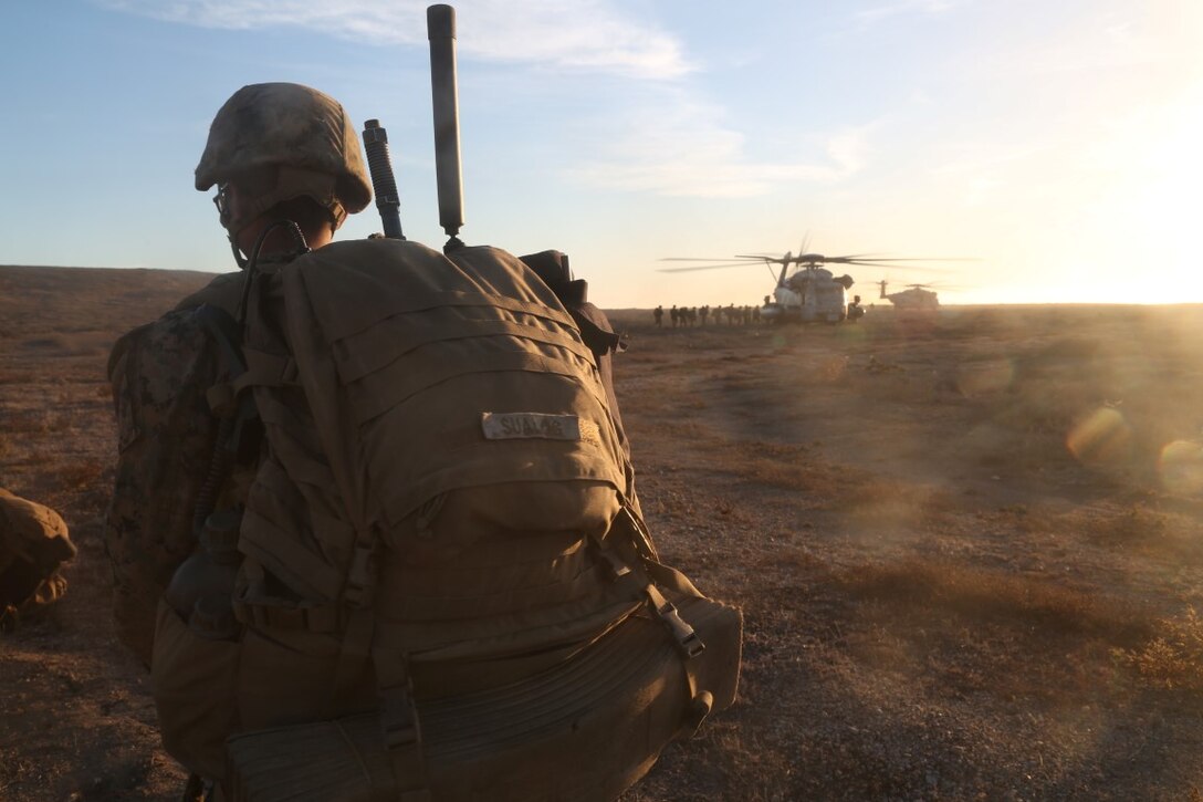 U.S. Marine Cpl. Colin Sualog with Battalion Landing Team 2/1, 13th Marine Expeditionary Unit (MEU), watches as part of his team loads U.S. Marine Corps CH-53 helicopters after completion of a mission to secure an airfield, local village and provide aid to refugees during Certificate Exercise (CERTEX) at San Clemente Island, California, Dec. 7, 2015. CERTEX is the final evaluation period of the 13th MEU and Boxer Amphibious Ready Group prior to deployment and is intended to certify their readiness to conduct integrated missions across the full spectrum of military operations. (U.S. Marine Corps photo by Cpl. Briauna Birl/RELEASED)