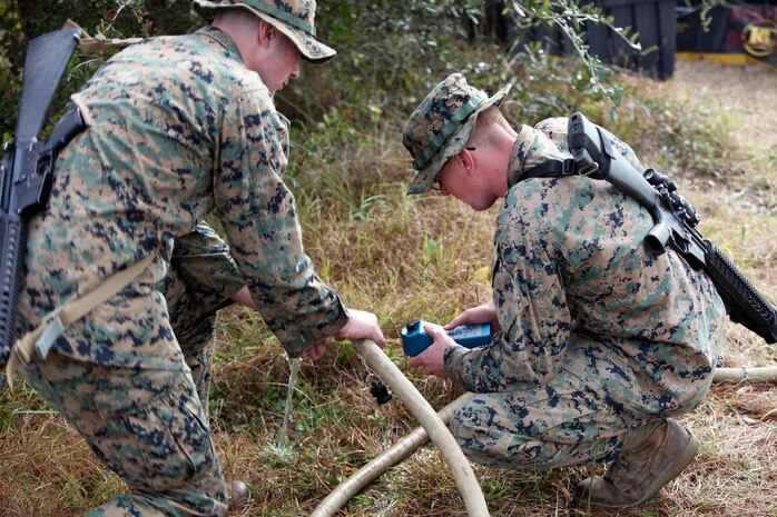 Lance Cpl. Quentin J. Stallings, left, and Lance Cpl. Kyle H. Clemens, right, configure the settings on a water pump and filter at Marine Corps Auxiliary Landing Field Bogue, N.C., Dec. 9, 2015. Marines with Marine Wing Support Squadron 271’s Engineer Company participated in a cantonment and capabilities field exercise to practice and improve their knowledge of their jobs while in a deployed environment. The week-long exercise featured events such as airfield damage repair, water purification, medium and heavy lifting missions, with the construction of an expedient road for a vertical take-off and landing aircraft pad. Stallings and Clemens are both water support technicians with MWSS-271. (U.S. Marine Corps photo by Pfc. Nicholas P. Baird/Released)