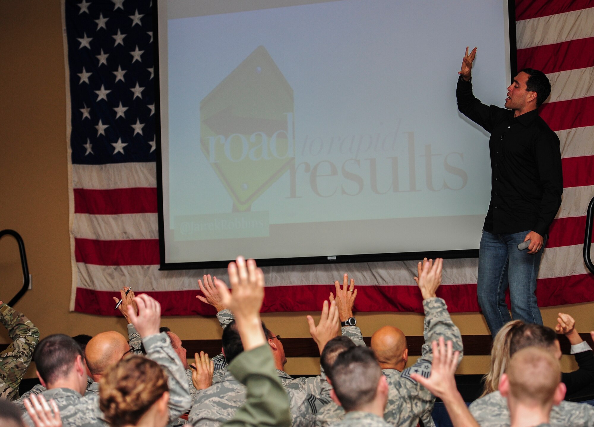 Jairek Robbins, a performance coach, asks Airmen to raise their hands as part of an exercise during his presentation at the Soundside Club, Hurlburt Field, Fla., Dec. 9, 2015. During the two-day visit, Robbins met with Airmen around Hurlburt Field to better understand Air Force Special Operations Command's mission and gave a motivational presentation to more than 300 Air Commandos at the end of his visit. (U.S. Air Force photo by Senior Airman Meagan Schutter)
