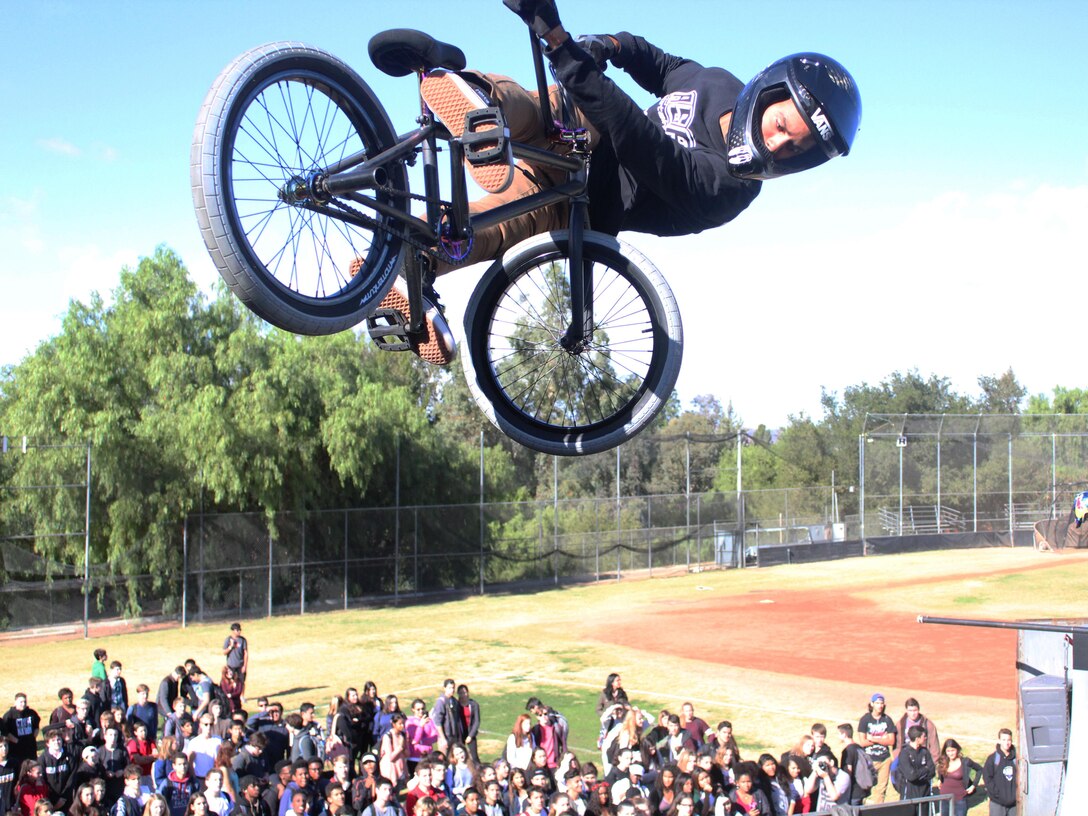 BMX biker Mykel Larrin performs a stunt in front of hundreds of students at Calabasas High School during the 2015 ASA High School Tour, Dec. 11. The tour is an interactive “extreme” sports show that visits high schools throughout the United States with several of the world’s top professional skateboarders, BMX bikers and inline skaters delivering an anti-bullying and anti-tobacco message. Recruiters from Recruiting Sub Station Granada Hills also attended the event and held a pull-up and flexed-arm hang challenge. (U.S. Marine Corps photo by Staff Sgt. Alicia R. Leaders/Released)