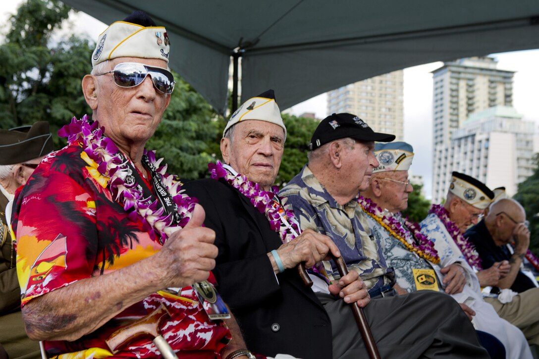 Bob Addott, left, gives a thumbs up as he and Thomas Petso attend the opening ceremony of the Pearl Harbor Memorial Parade on Fort DeRussy Park in Honolulu, Dec. 7, 2015. U.S. Marine Corps photo by Lance Cpl. Miguel Rosales