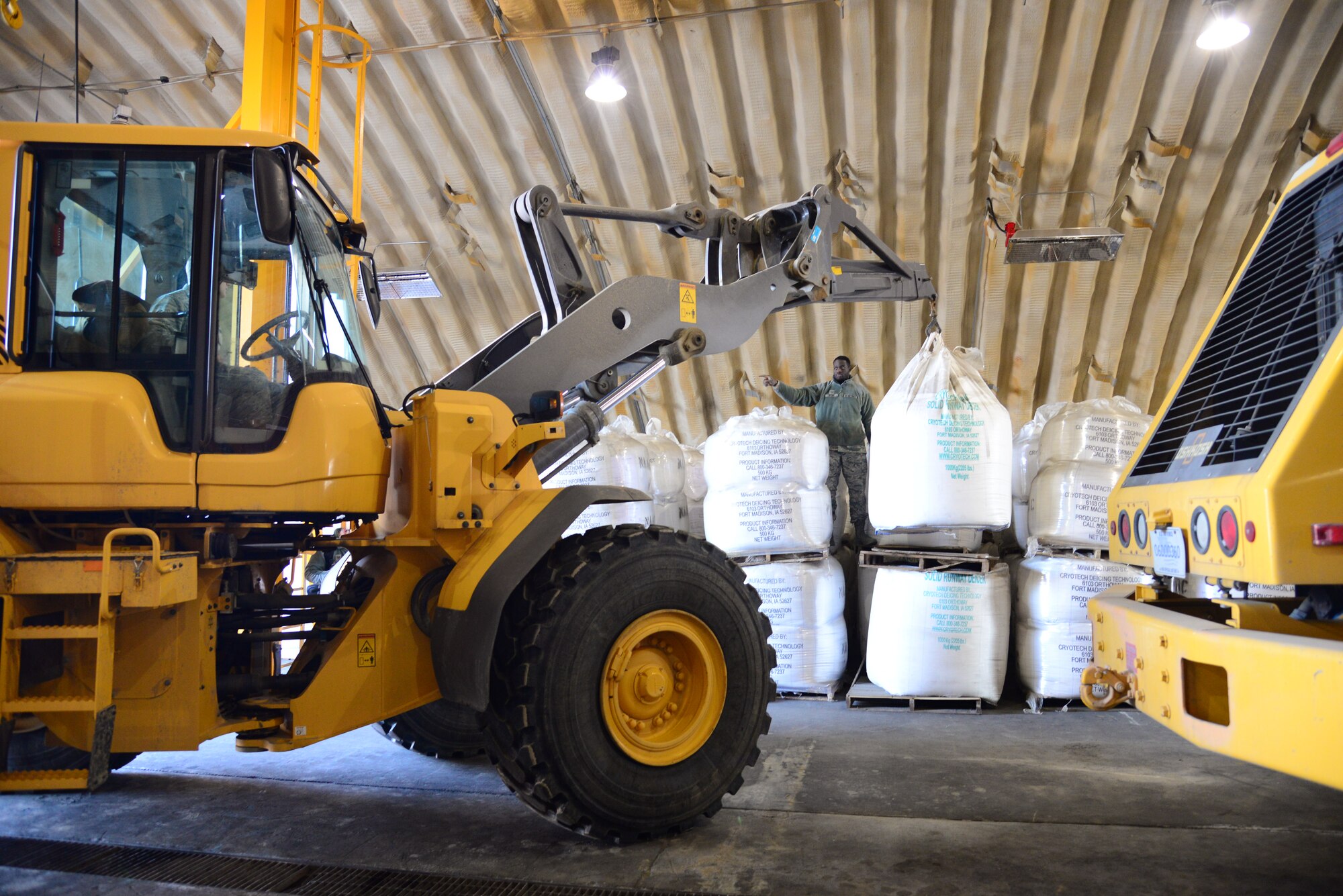 Staff Sgt. Ernest Opoku, 51st Civil Engineer Squadron pavement and construction equipment craftsman, directs the movement of a 1,100 pound bag of deicing chemicals at Osan Air Base, Republic of Korea, Dec. 8, 2015.  With an estimated five inches of snow already fallen, winter preparations are important to maintain the continued functionality of the base. (U.S. Air Force photo/Staff Sgt. Amber Grimm)