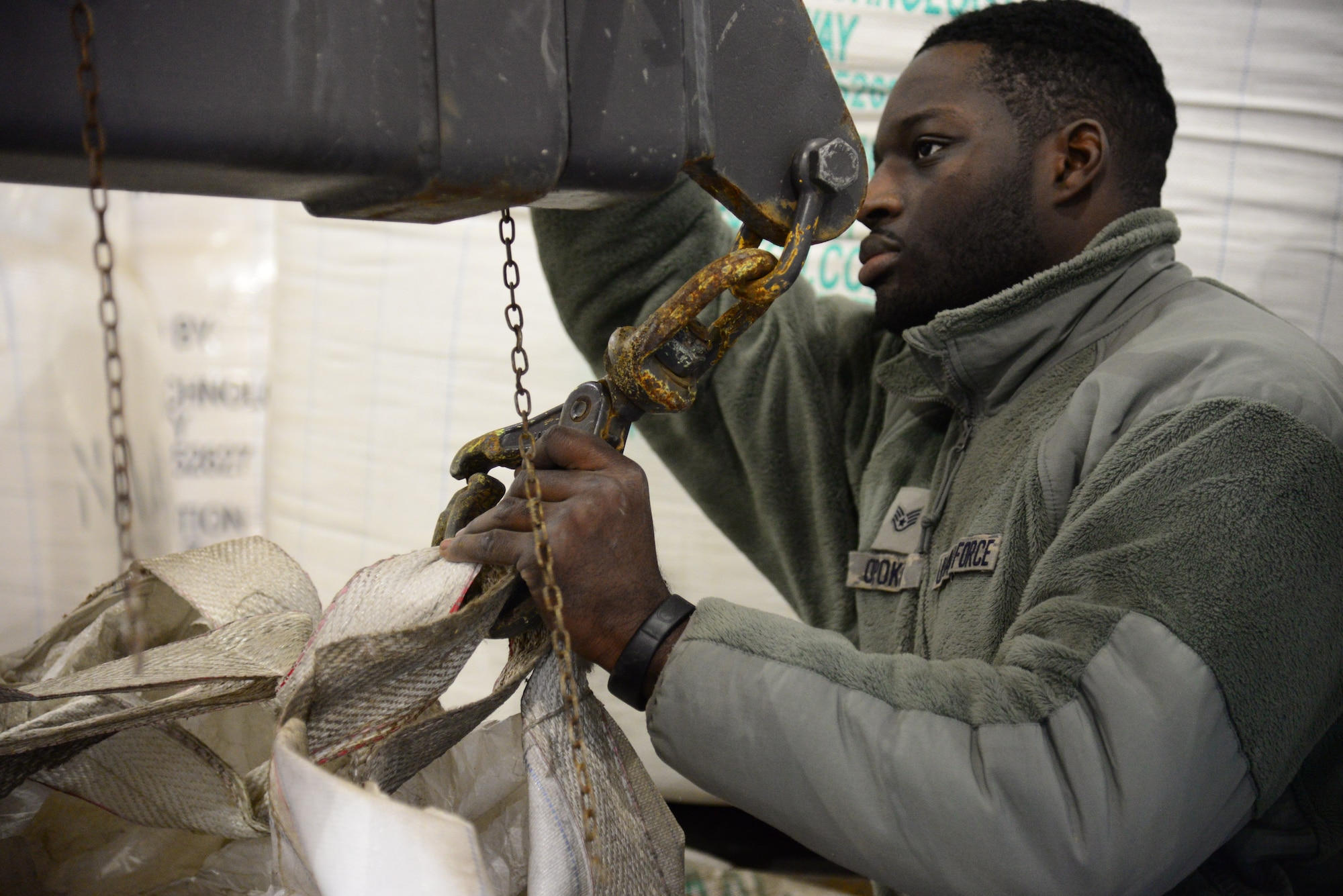 Staff Sgt. Ernest Opoku, 51st Civil Engineer Squadron pavement and construction equipment craftsman, preps a 1,100 pound bag of deicing chemicals at Osan Air Base, Republic of Korea, Dec. 8, 2015.  The chemicals, once mixed with sand, will be used to keep the roads clear of ice while providing vehicles with additional traction.  (U.S. Air Force photo/Staff Sgt. Amber Grimm)