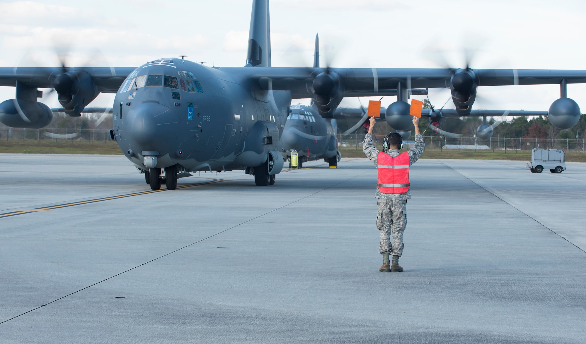 U.S. Air Force Airman 1st Class Jonathan Marquez, 71st Rescue Squadron crew chief, marshals in an HC-130J Combat King II, Dec. 11, 2015, at Moody Air Force Base, Ga. The aircraft is the 2,500th C-130 manufactured by Lockheed Martin Corporation in Marietta, Ga. (U.S. Air Force Senior Airman Ceaira Tinsley/Released)