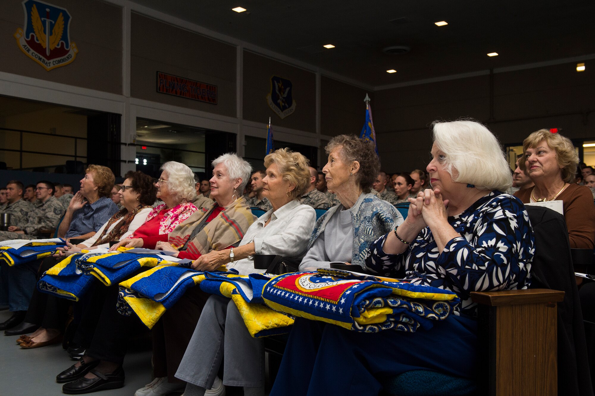 Members of a local quilting guild, await to award quilts during the Quilts of Valor presentation, Dec. 9, 2015, at Moody Air Force Base, Ga. The quilters handmade seven quilts for Purple Heart recipients and two Airmen from the 820th Base Defense Group were attended the presentation. (U.S. Air Force photo by Senior Airman Ceaira Tinsley/Released)