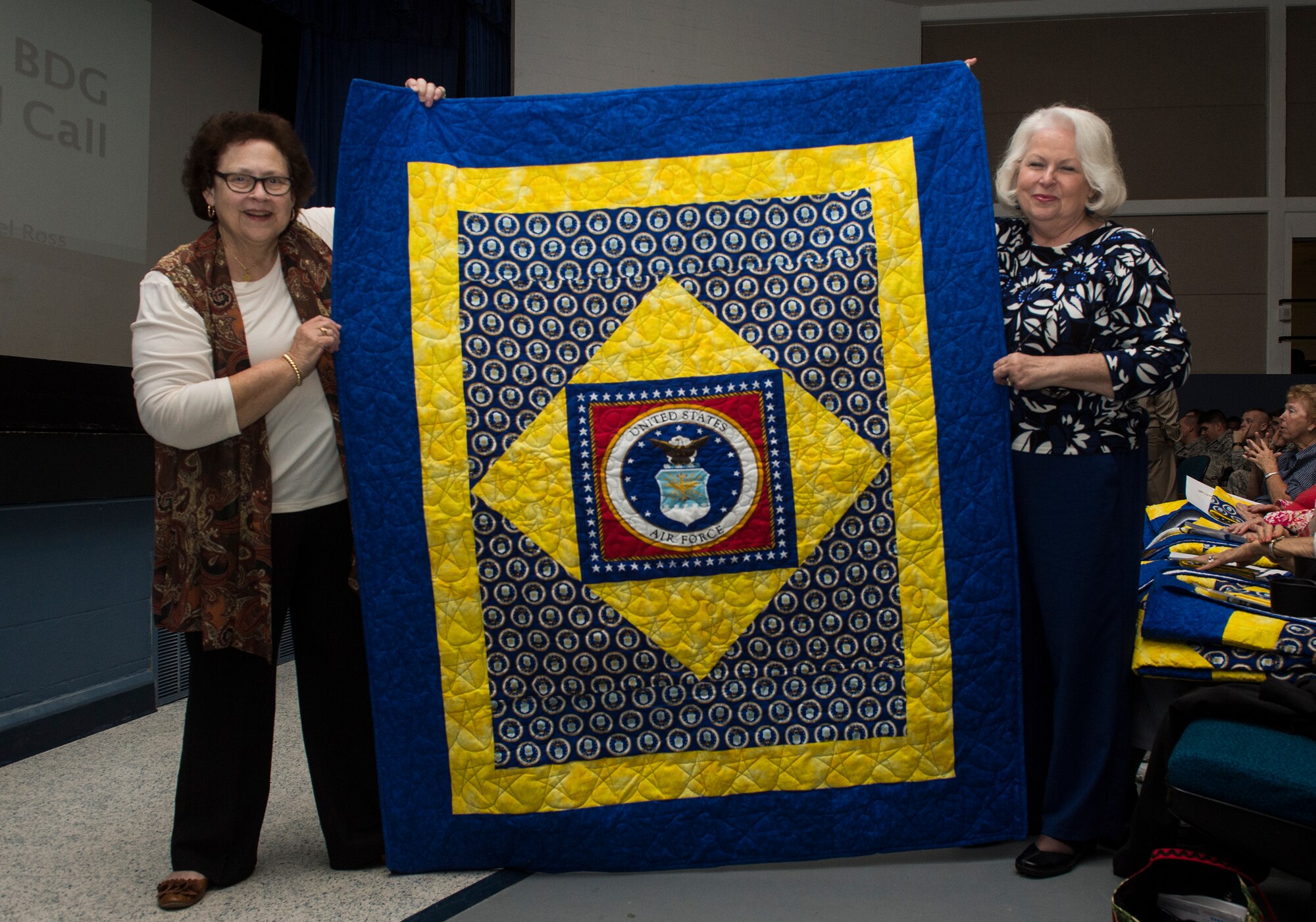 Zella Fuller, (left), and Marsha Tyson, members of a local quilting guild, pose for a photo during the Quilts of Valor presentation, Dec. 9, 2015, at Moody Air Force Base, Ga. Fuller began making quilts in 2004 for the Quilts of Valor Foundation and since then has made more than 200 quilts. (U.S. Air Force photo by Senior Airman Ceaira Tinsley/Released)