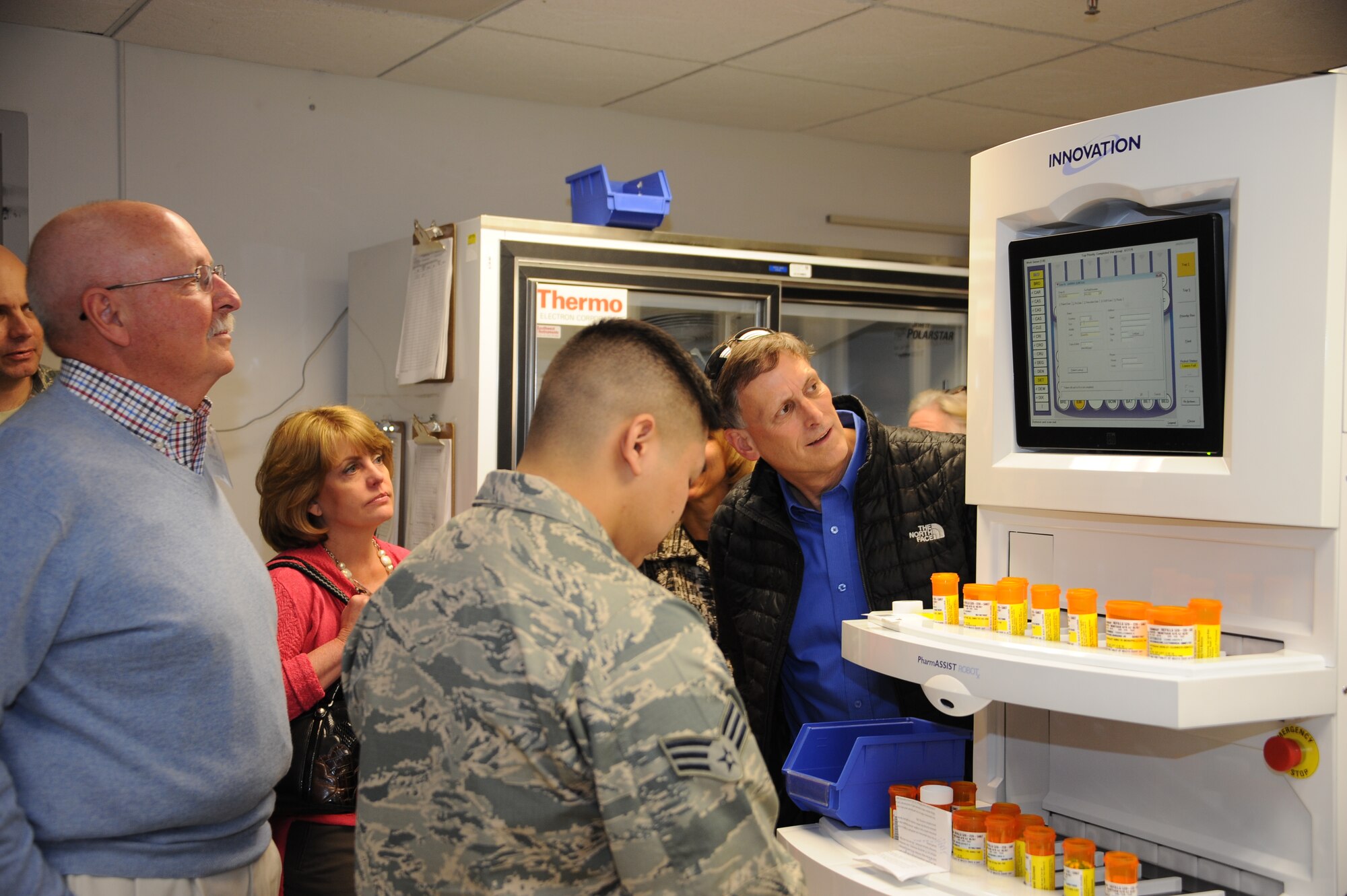 U.S. Air Force Senior Airman Paul Ebiya, 355th Medical Support Squadron pharmacy technician, shows members of the base’s Honorary Commanders Program a demonstration  of the new pharmacy machine, the Pharmassist, at Davis-Monthan Air Force Base, Ariz., Dec. 2, 2015. The Pharmassist can refill 100 prescriptions per hour with little to no mistakes. (U.S. Air Force photo by Airman 1st Class Ashley N. Steffen/Released)