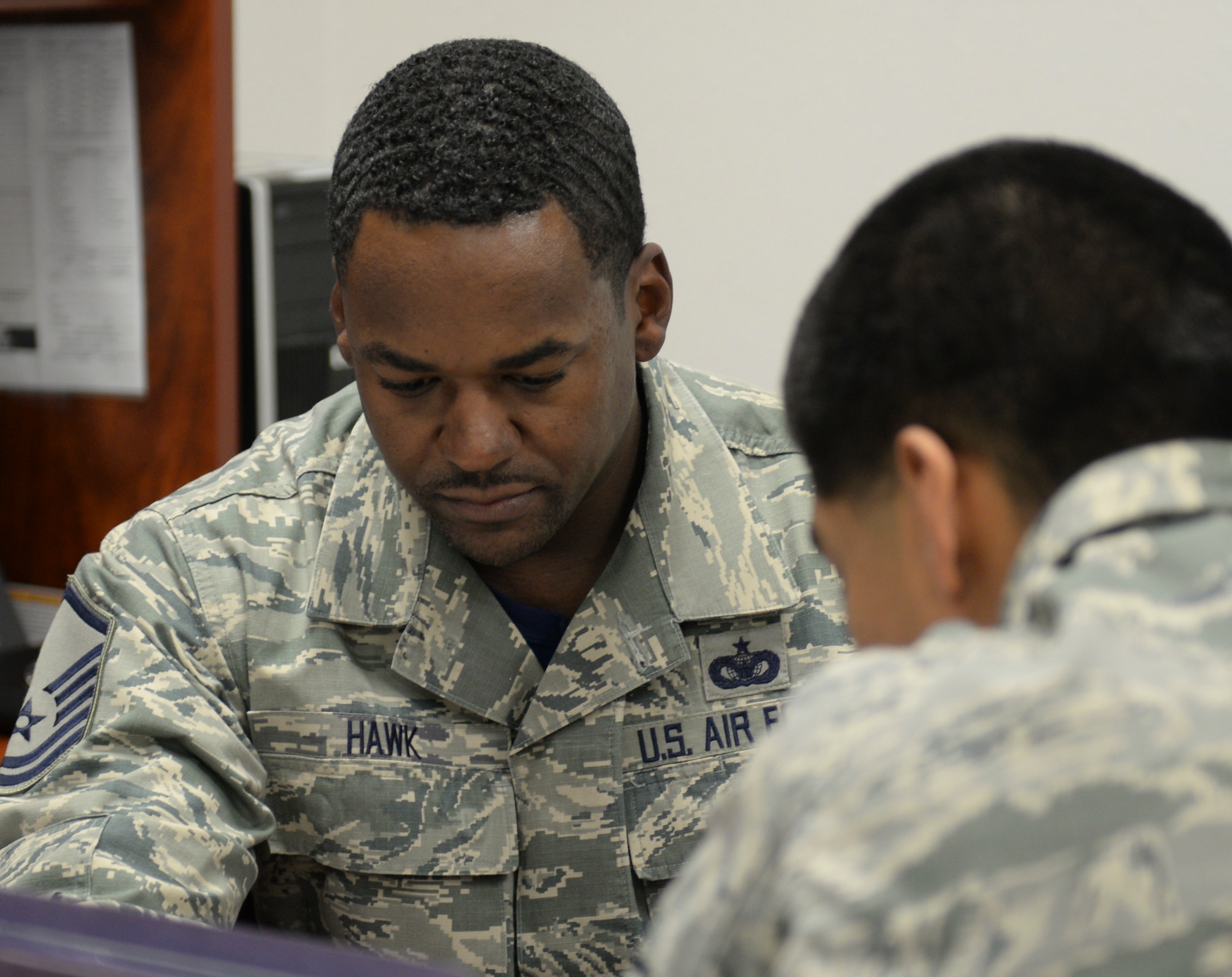 Master Sgt. Bryan Hawk, the noncommissioned officer in-charge of Judge Advocate training and readiness, assists Senior Airman Geovanni Nunez, a 49th vehicle maintenance journeyman, with a deployment checklist during the Legal Hawk Outreach Program visit to the 49th Material Maintenance Support Squadron at Holloman Air Force Base, New Mexico on Dec. 4. The legal office recently cut back the number of walk-in legal assistance appointments due to manning issues. The outreach program was created to provide quality legal assistance to those who were having difficulty making it to the legal office. (U.S. Air Force photo by Staff Sgt. E’Lysia A. Wray)