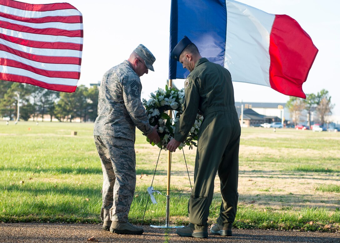 U.S. Air Force Col. Pete Fesler, commander of the 1st Fighter Wing, and Chief Master Sgt. Ronald Beadles, 1st FW chief master sergeant, lays a wreath in front of a French flag at Langley Air Force Base, Va., Dec. 11, 2015. The wreath-laying ceremony was held in remembrance of the victims of recent terrorist attacks in Paris, France. (U.S. Air Force photo by Airman 1st Class Derek Seifert)