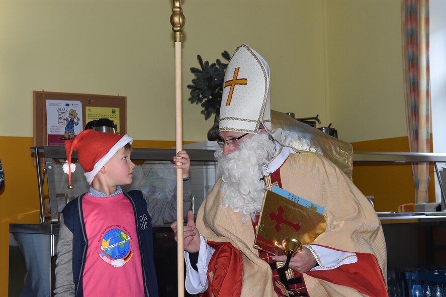 A boy from the Bitburg Saint Martin School holds the Nikolaus pole for Sankt Nikolaus, who traditionally visits the school children for their annual holiday party, Dec. 7 in Bitburg.  Among the visitors were school officials, teachers and parents, as well as a delegation from Spangdahlem Air Base consisting of Airmen, spouses and civilians who handed out holiday gifts at the celebration. (U.S. Air Force photo by Iris Reiff)