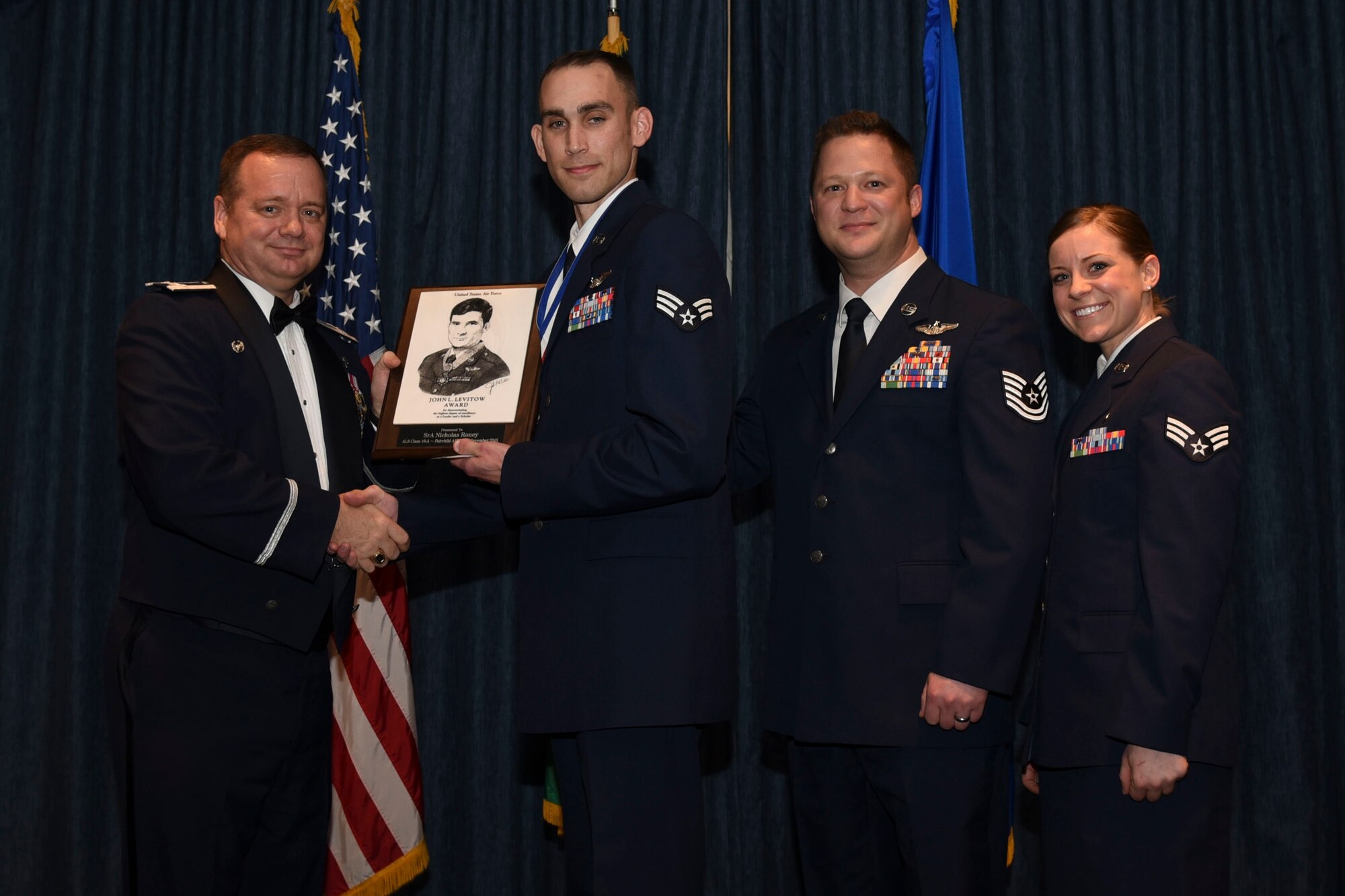 Senior Airman Nicholas Roney from the 92nd Operations Group receives the John L. Levitow Award during the Airman Leadership School graduation Dec. 10, 2015, at Fairchild Air Force Base, Wash. The Levitow Award is presented to the student who demonstrated the most outstanding leadership and scholastic qualities. (U.S. Air Force photo/Airman 1st Class Mackenzie Richardson)