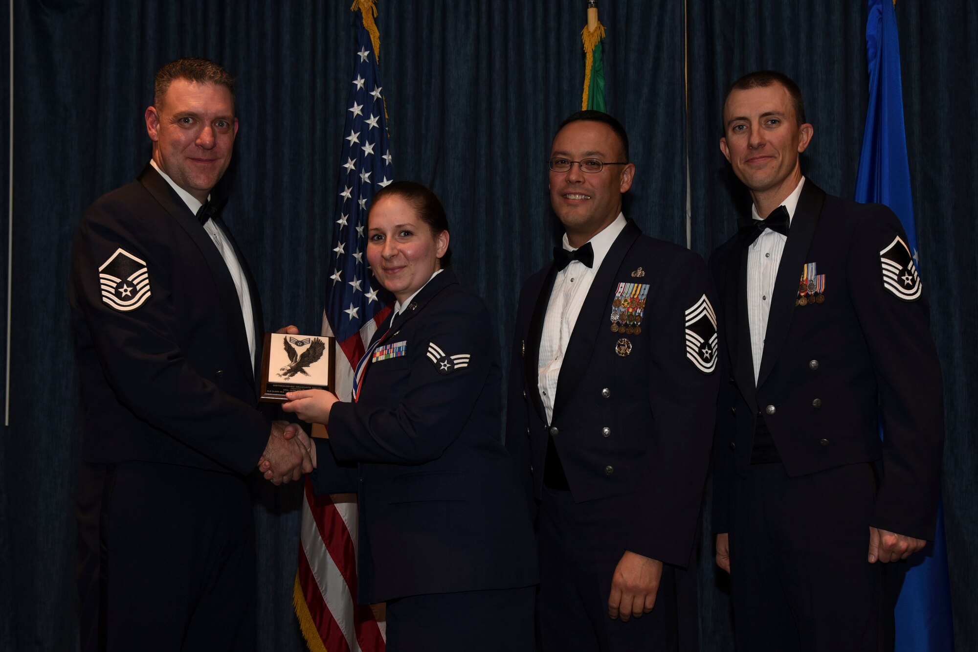 Senior Airman Jaimi Prussner from the 336th Training Squadron receives one of two distinguished graduate awards during the Airman Leadership School graduation Dec. 10, 2015, at Fairchild Air Force Base, Wash. The Distinguished Graduate Award is presented to the graduates in the top ten percent of the class based on the highest overall average in all graded areas. Prussner was also awarded the Academic Achievement Award. The Academic Achievement Award is presented to the student with the highest overall average on all academic evaluations. (U.S. Air Force photo/Airman 1st Class Mackenzie Richardson)