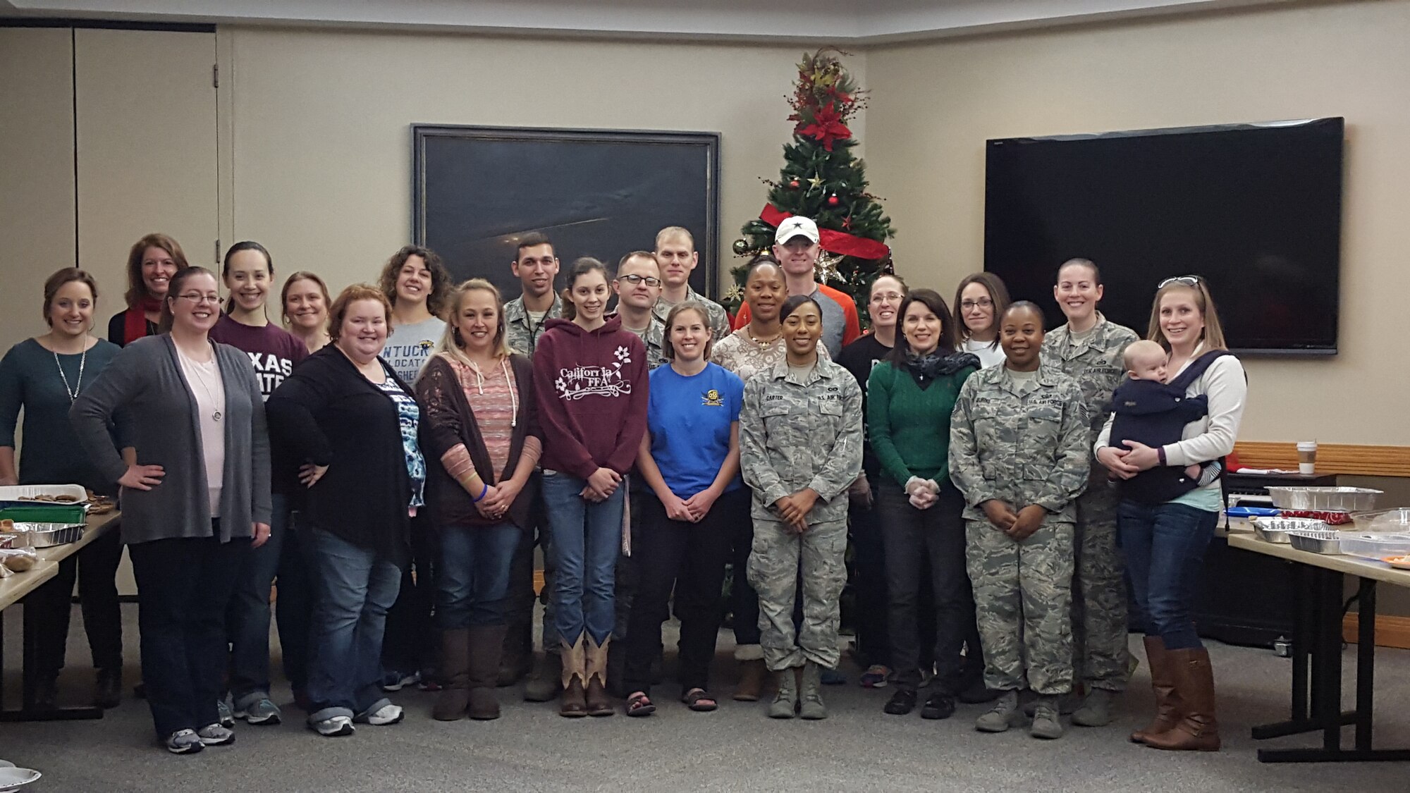Team Whiteman volunteers gather for a group photo during a holiday cookie drive at Whiteman Air Force Base, Mo., Dec. 10, 2015. Volunteers collected, divided, bagged and distributed more than 600 cookies to unaccompanied and single Airmen living in the dorms. (U.S. Air Force photo by Tech. Sgt. Miguel Lara III)
