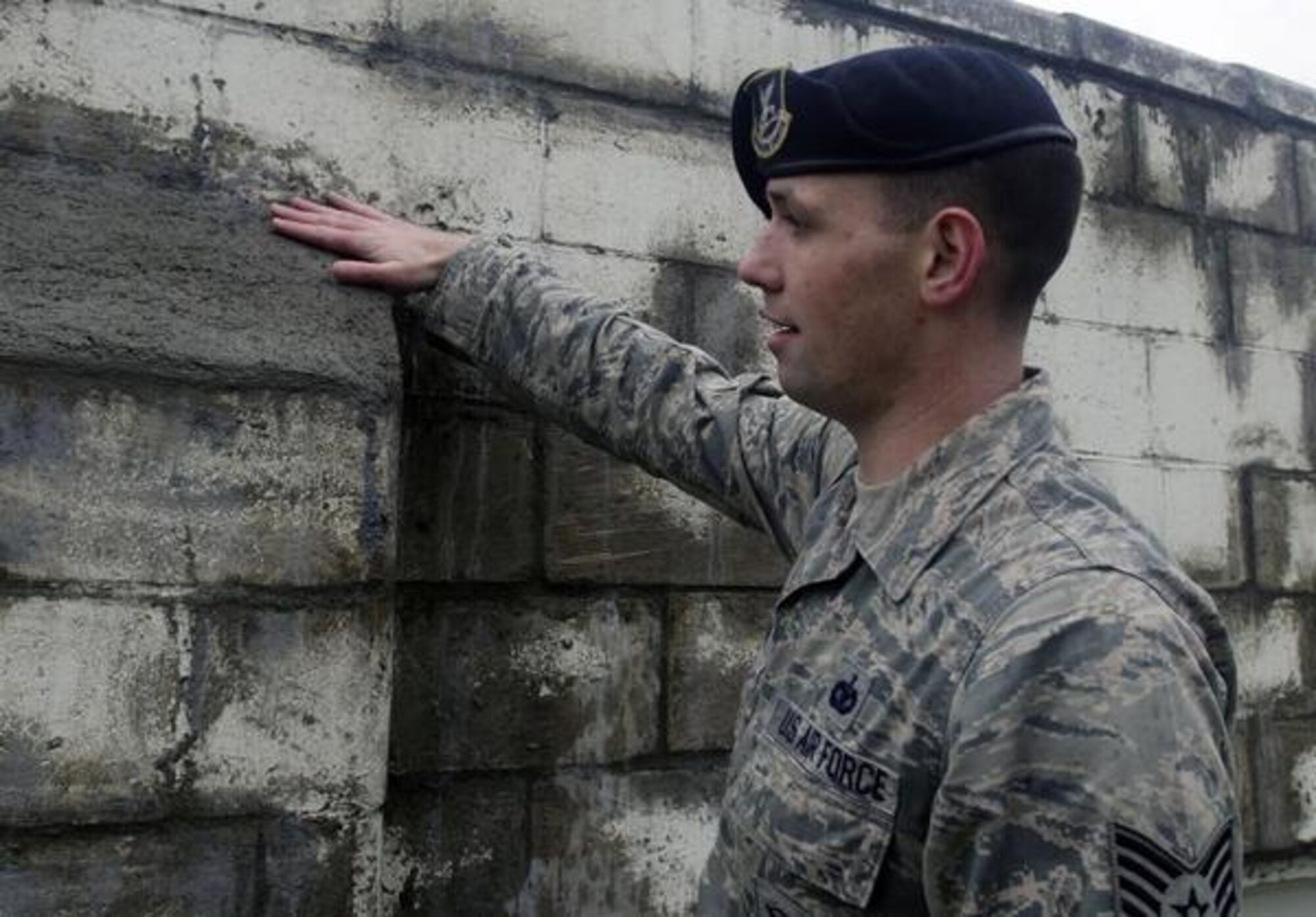 Staff Sgt. Daniel Watkins, 627th Security Forces Squadron’s base defense operations controller, looks over his work of a wall he reconstructed at the Empowerment Center Dec. 5 in Tacoma. Watkins and two other Airmen from his unit recently repaired the 60-foot long by 10-foot high wall.(U.S. Air Force Photo/Senior Airman Jacob Jimenez)