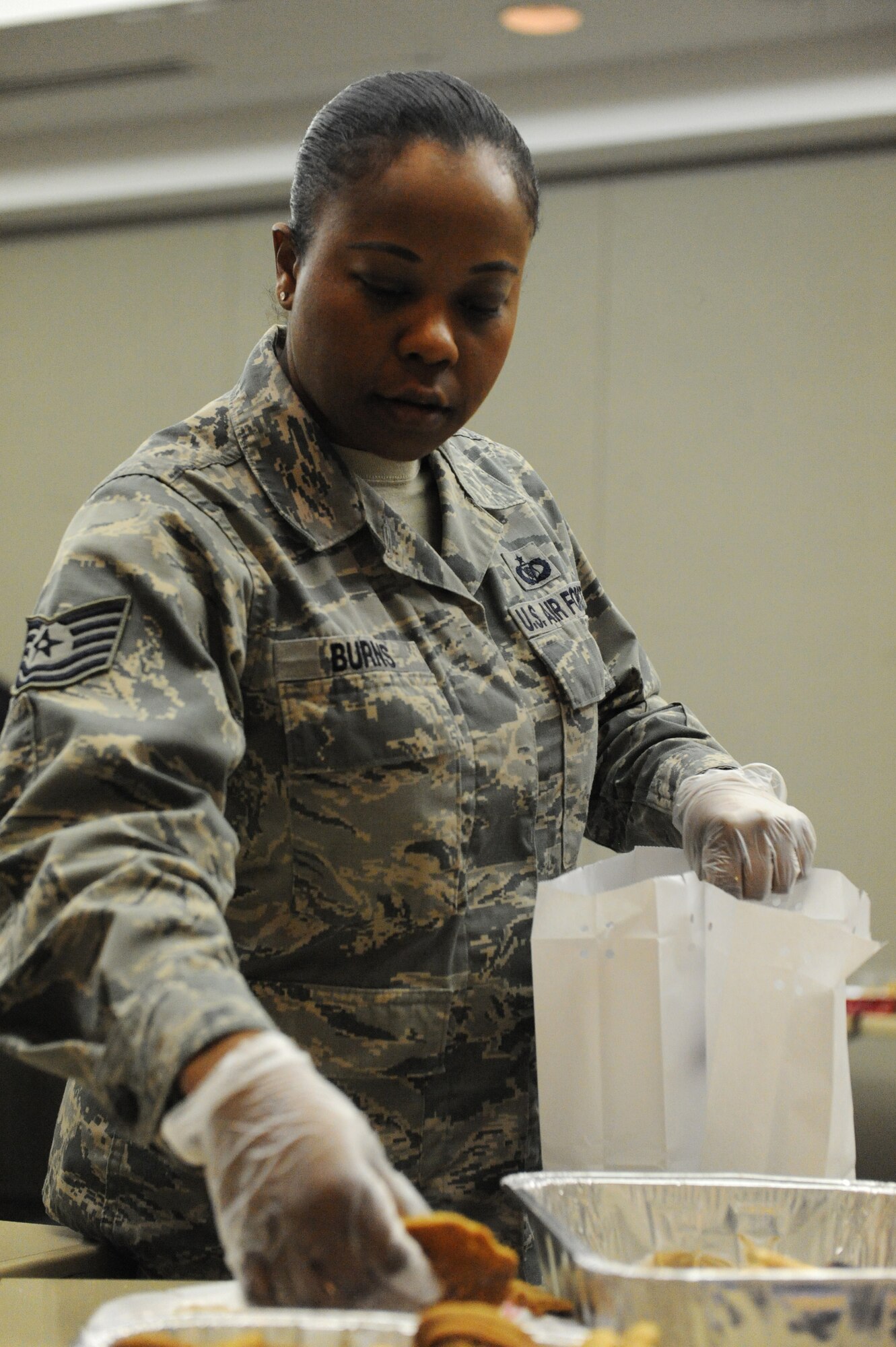 U.S. Air Force Tech. Sgt. Dawn Burns, the 509th Operations Support Squadron harms office NCO in charge, collects cookies during a holiday cookie drive at Whiteman Air Force Base, Mo., Dec. 10, 2015. The Whiteman spouses group hosted the annual cookie drive where volunteers collected, bagged and packaged more than 600 cookies to unaccompanied and single Airmen living in the dorms. (U.S. Air Force photo by Tech. Sgt. Miguel Lara III)