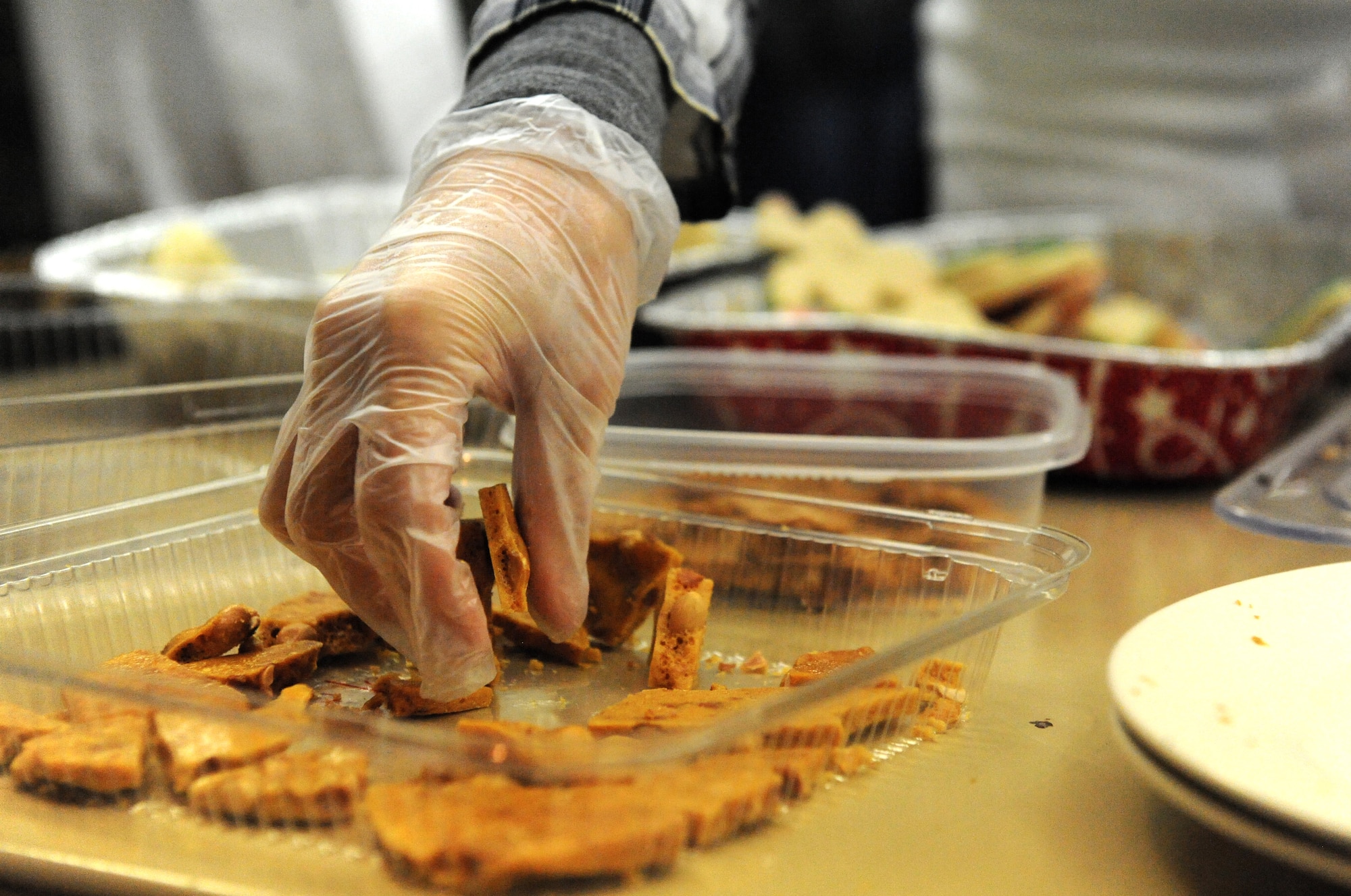 A volunteer collects peanut brittle during a cookie drive held at Whiteman Air Force Base, Mo., Dec. 10, 2015.  The Whiteman spouses group hosted the annual holiday cookie drive where volunteers collected, bagged and packaged more than 600 cookies to donate unaccompanied and single Airmen living in the dorms. (U.S. Air Force photo by Tech. Sgt. Miguel Lara III)