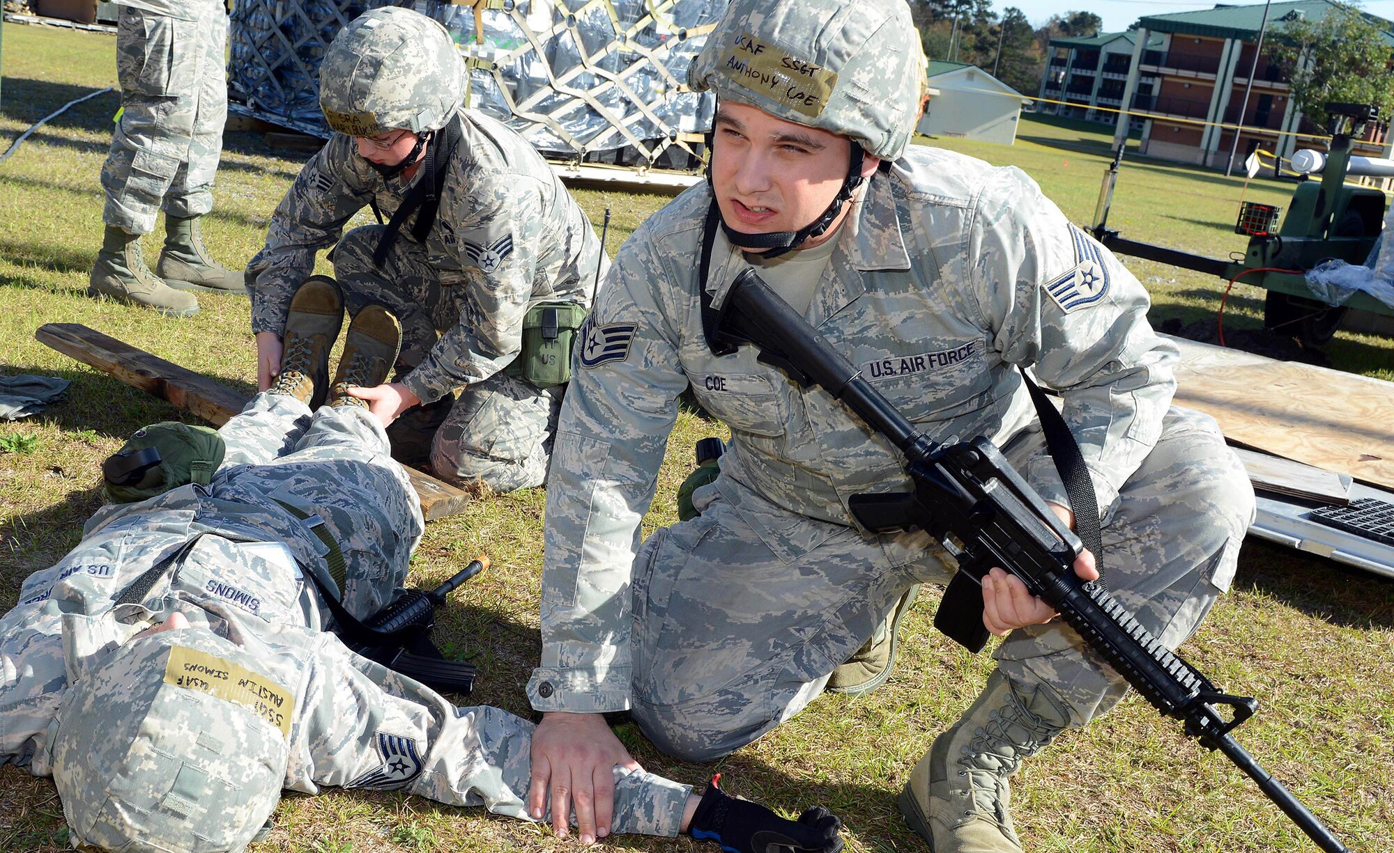 Staff Sgt. Anthony Coe, Radio Frequency Transmission Systems supervisor (front), and Senior Airman Zachary Blucker, 51st Combat Communications Squadron, perform self-aid and buddy care on Staff Sgt. Austin Simons following a simulated attack Dec. 7 at a Georgia Air National Guard Combat Readiness Training Center in Savannah. (U.S. Air Force photo by Tommie Horton)