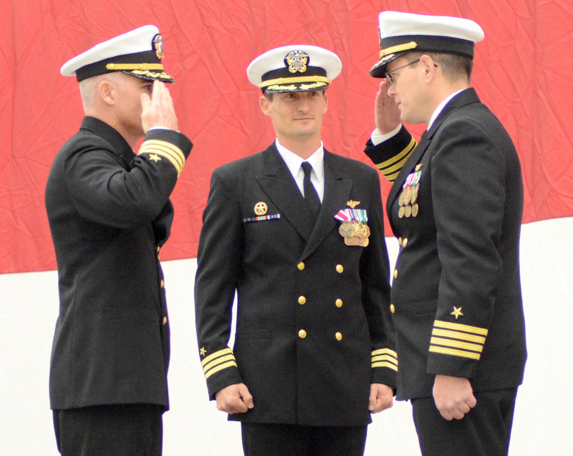 Capt. Brian McCormick, right, commander of Strategic Communications Wing 1 and Task Force 124, salutes Cdr. Mark Brophy, left, to welcome him as the new commander for Fleet Air Reconnaissance Squadron Seven during a Nov. 20 change of command ceremony. (Air Force photo by Kelly White/Released)