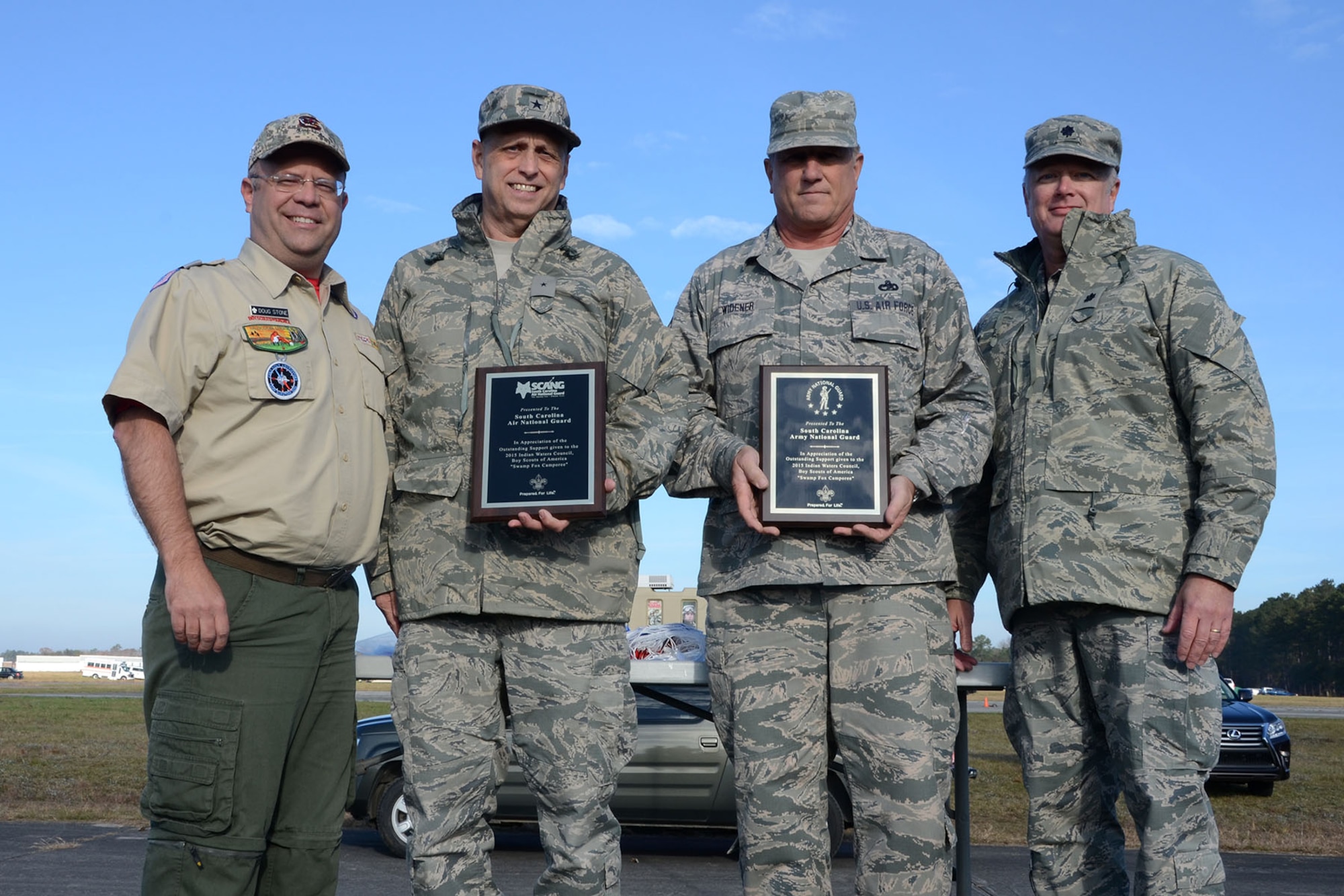 Doug Stone, the Indian Waters Council executive, presents U.S. Air Force Brig. Gen. Russell Rushe, Assistant Adjutant General for Air, with plaques of appreciation for the Air and Army National Guard at McEntire Joint National Guard Base, S.C., during the Swamp Fox Camporee Dec. 6, 2015. The event was hosted by the South Carolina National Guard to allow Cub Scouts and Boy Scouts the opportunity to interact with Guardsmen and compete to earn various merit badges. (U.S. Air National Guard photo by Airman Megan Floyd/RELEASED))