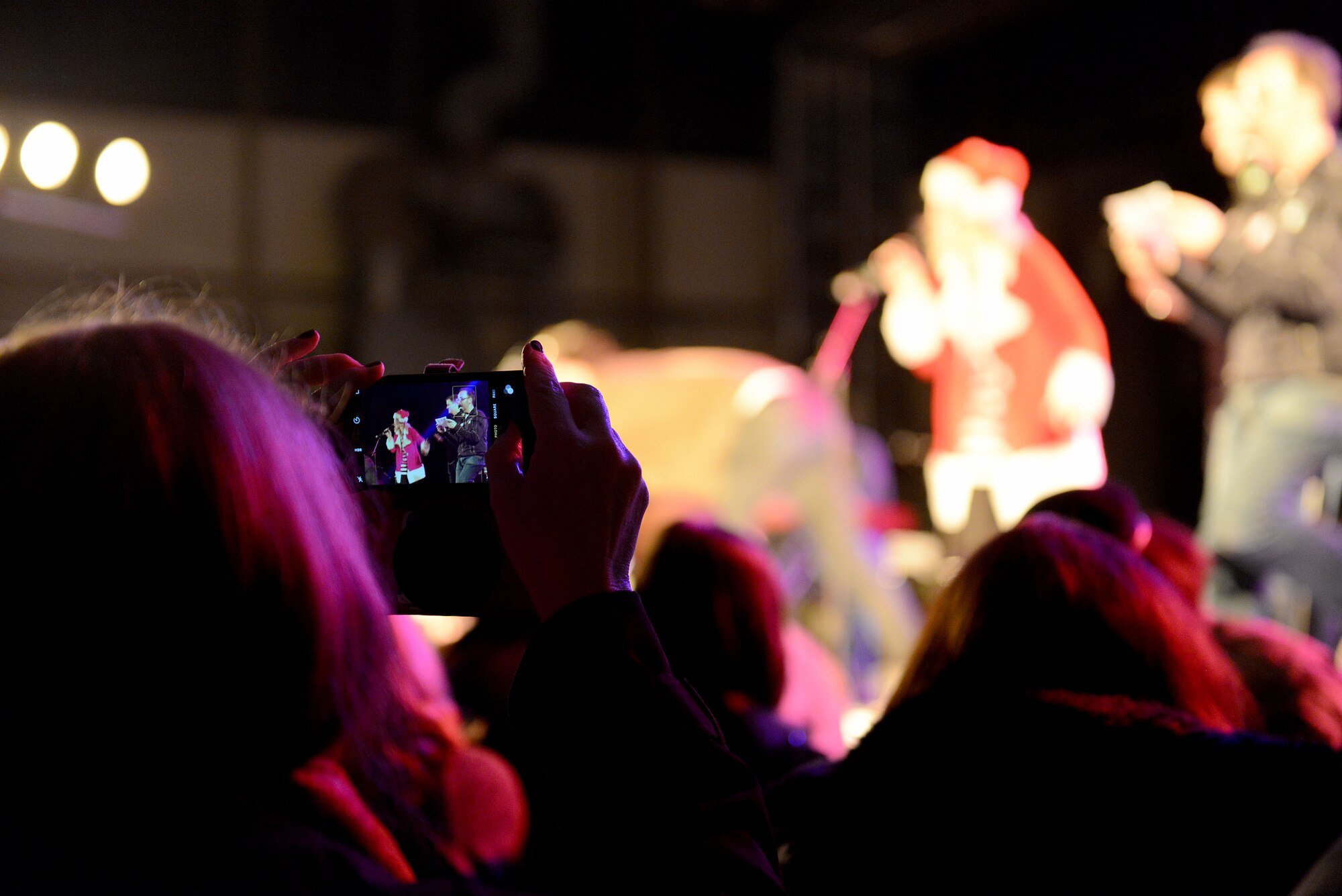 A crowd member takes a photo of participants of the 2015 USO Holiday Troop Tour Dec. 9, 2015, at Ramstein Air Base, Germany. Participants included actors Elizabeth Banks and David Wain as well as Boston Red Sox players Heath Hembree and Steven Wright. The tour is a way to say thanks to the service members and their families. (U.S. Air Force photo/Staff Sgt. Timothy Moore)