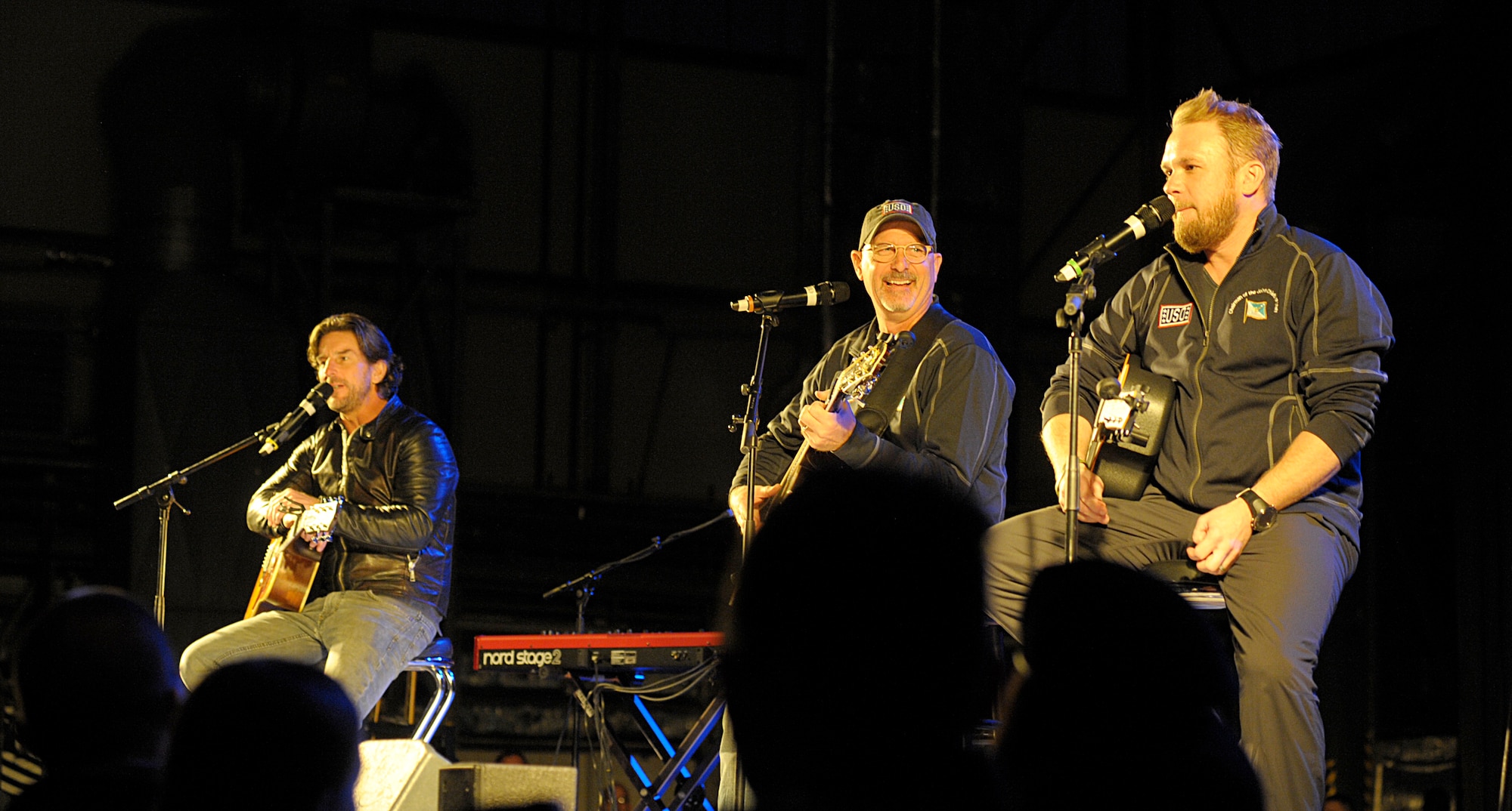 From left, singers and songwriters Brett James, Billy Montana and Kyle Jacobs perform a song during the 2015 USO Holiday Troop Tour Dec. 9, 2015, at Ramstein Air Base, Germany. The performers joined other celebrities and the chairman of the Joint Chiefs of Staff to visit service members and their families on the overseas tour. (U.S. Air Force photo/Staff Sgt. Timothy Moore)