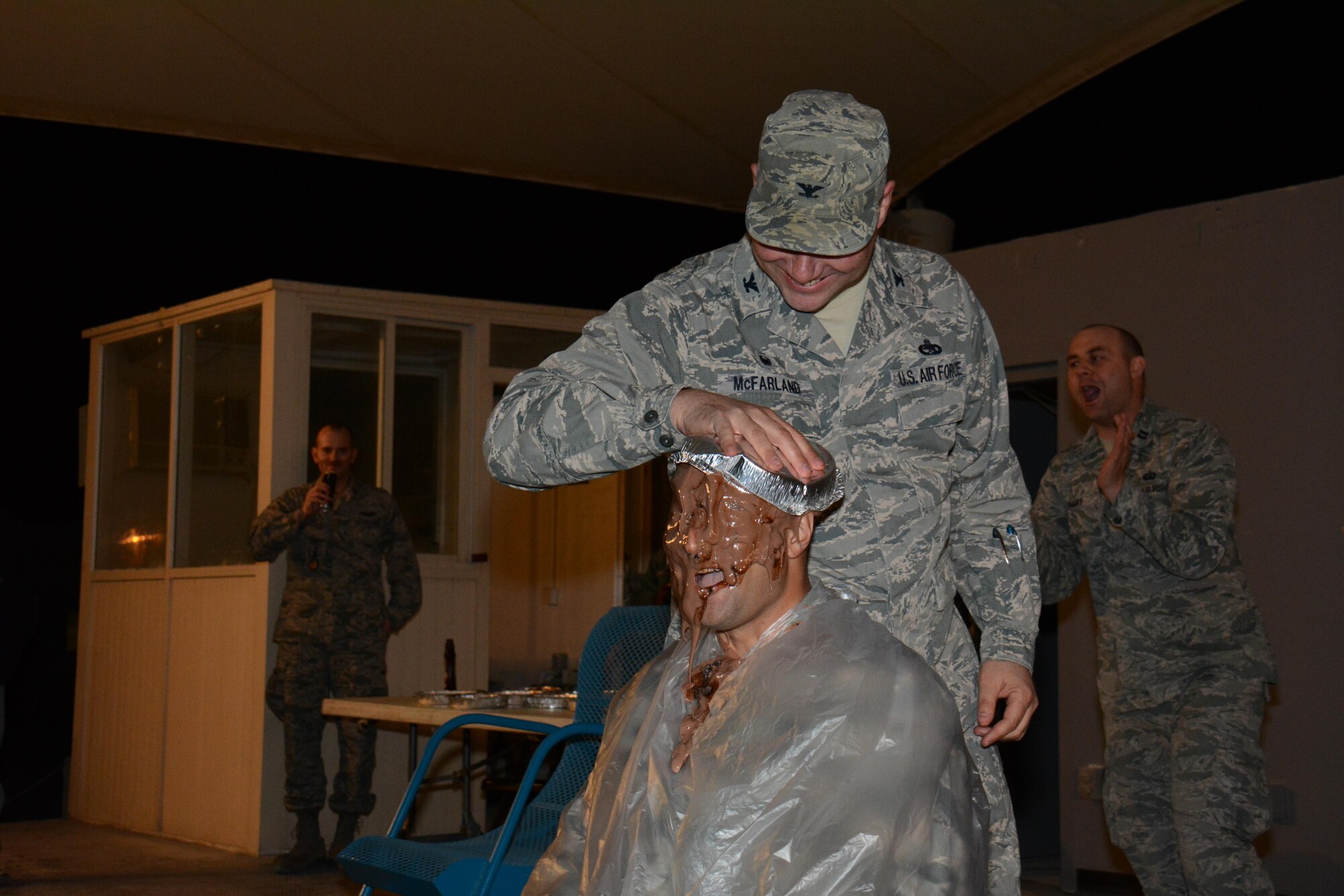 Col. Charles McFarland, 379th Expeditionary Maintenance Group commander, slams Maj. Joshua Depaul, 379th Expeditionary Maintenance Squadron commander, with a pie during a Pie-in-the-Face event inside Memorial Plaza at Al Udeid Air Base, Qatar Dec. 9. During the event, which raised more than $4,000 for 27 charities, 11 people were slammed in the face with pies. (U.S. Air Force photo by Tech. Sgt. James Hodgman/Released)