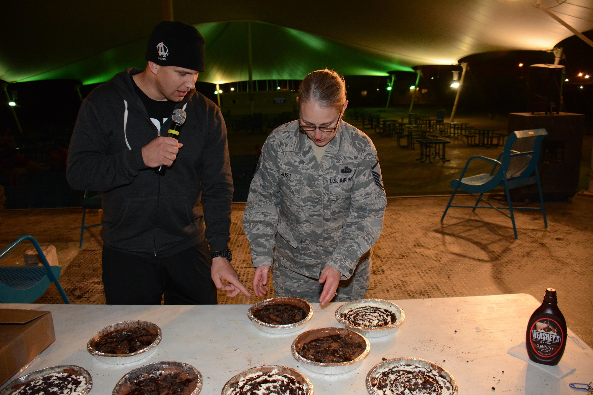 Master Sgt. Cynthia Just, 379th Air Expeditionary Wing Plans and Programs senior non-commissioned officer in charge, chooses a pie to throw in the face of Lt. Col. Adam Reiman, 379th AEW chief of Plans and Programs, during a Pie-in-the-Face fundraiser to close the Combined Federal Campaign Overseas at Al Udeid Air Base, Qatar Dec. 9. The event raised more than $4,000 for 27 charities. (U.S. Air Force photo by Tech. Sgt. James Hodgman/Released)

