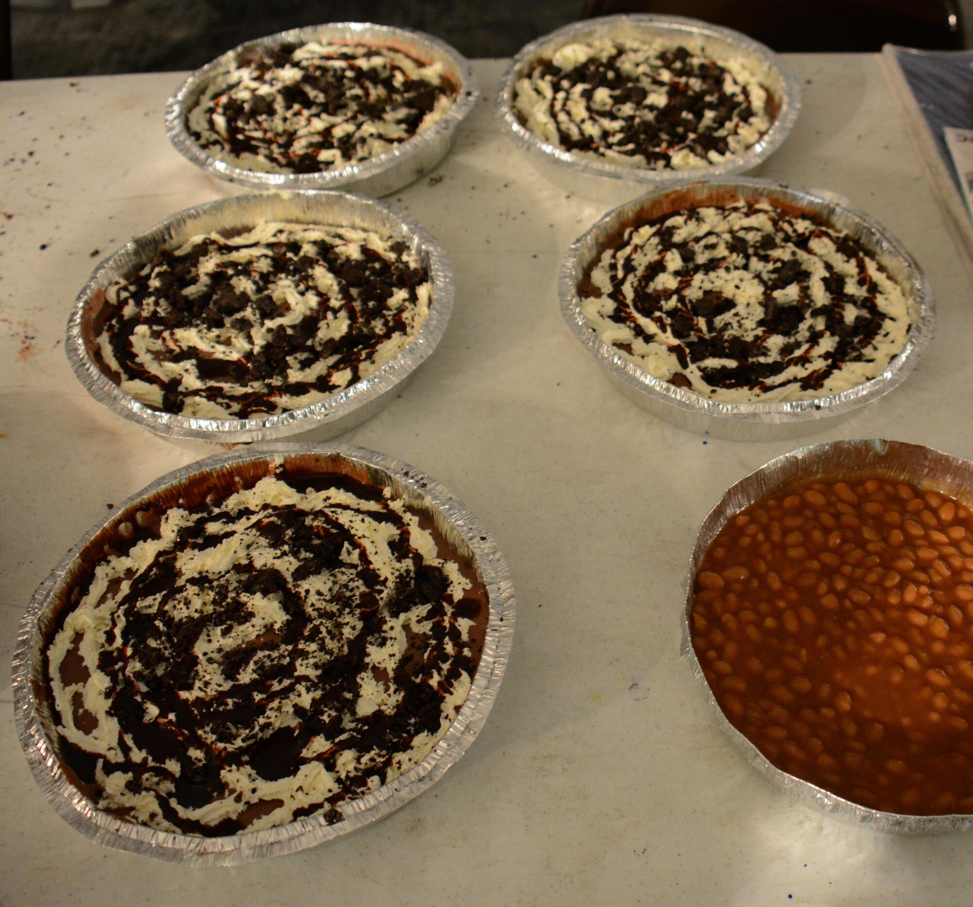 Six pies containing a variety of ingredients sit on a table inside Memorial Plaza at Al Udeid Air Base, Qatar Dec. 9. The pies were used during a Pie-in-the-Face event to close the annual Combined Federal Campaign Overseas for 2015. During the event, which raised more than $4,000 for 27 charities, 11 people were slammed in the face with pies. (U.S. Air Force photo by Tech. Sgt. James Hodgman/Released)