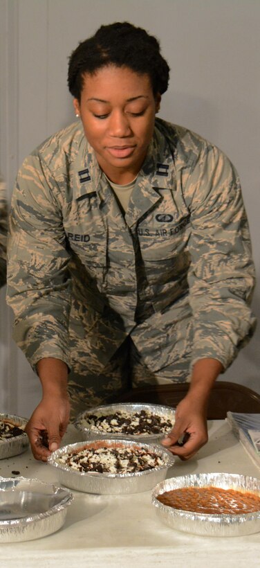 Capt. Aleksi Reid, 379th Expeditionary Comptroller Squadron, prepares pies for a Pie-in-the-Face event inside Memorial Plaza at Al Udeid Air Base, Qatar Dec. 9. The pies were used during a Pie-in-the-Face event to close the annual Combined Federal Campaign Overseas for 2015. During the event, which raised more than $4,000 for 27 charities, 11 people were slammed in the face with pies. (U.S. Air Force photo by Tech. Sgt. James Hodgman/Released)