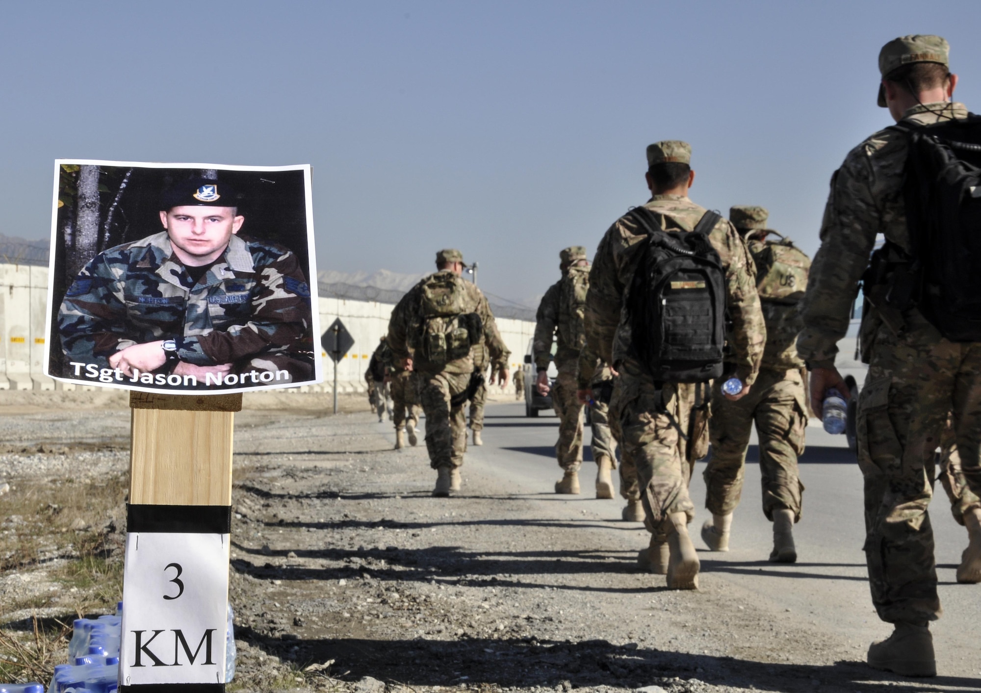 Bagram service members ruck march past a memorial marker of Tech. Sgt. Jason Norton, one of the 12 Defenders who lost their life in Iraq and Afghanistan, during the “Ruck to Remember,” a 12-kilometer ruck march at Bagram Airfield, Afghanistan Dec. 12, 2015. The event was designed to honor the sacrifices these Defenders made and to celebrate their lives. (U.S. Air Force photo by Tech. Sgt. Nicholas Rau/Released)