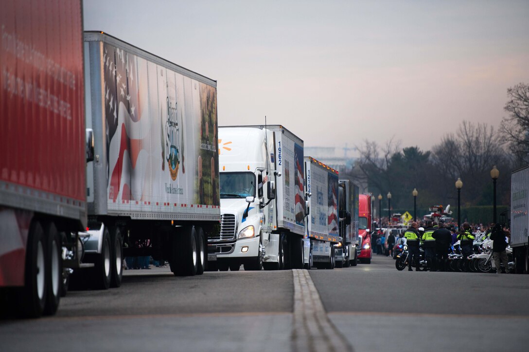 A procession of trucks drive down Memorial Avenue carrying remembrance wreaths to Arlington National Cemetery, Arlington, Va., Dec. 12, 2015. Thousands of volunteers helped place more than 240,851 wreaths at the graves of fallen service members during the annual Wreaths Across America event. U.S. Army photo by Rachel Larue