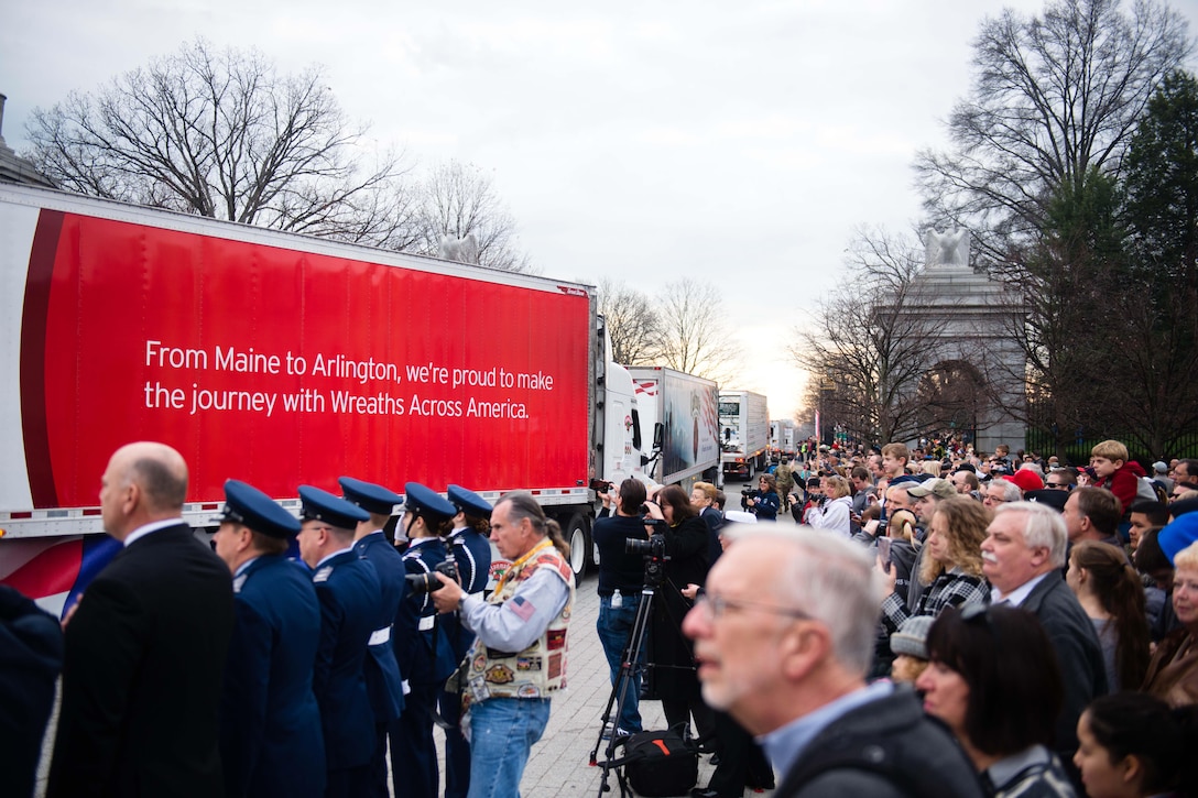 Volunteers look on as trucks carrying remembrance wreaths arrive at Arlington National Cemetery, Arlington, Va., Dec. 12, 2015. U.S. Army photo by Rachel Larue