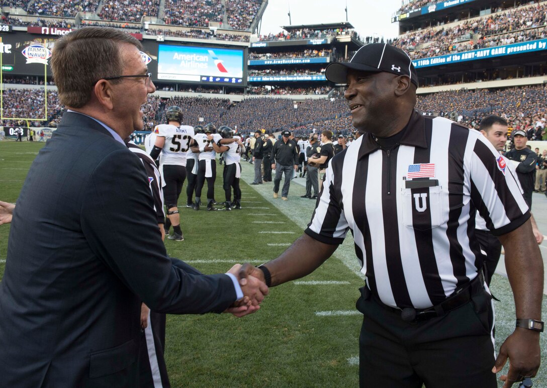 Defense Secretary Ash Carter shakes hands with a referee at the 2015 Army-Navy football game in Philadelphia, Dec. 12, 2015.