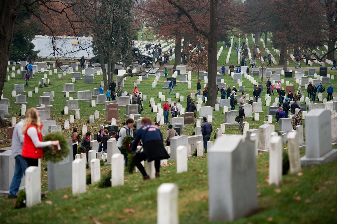 Volunteers place wreaths on grave markers during the annual Wreaths Across America event in Arlington National Cemetery in Arlington, Va., Dec. 12, 2015. U.S. Army photo by Rachel Larue