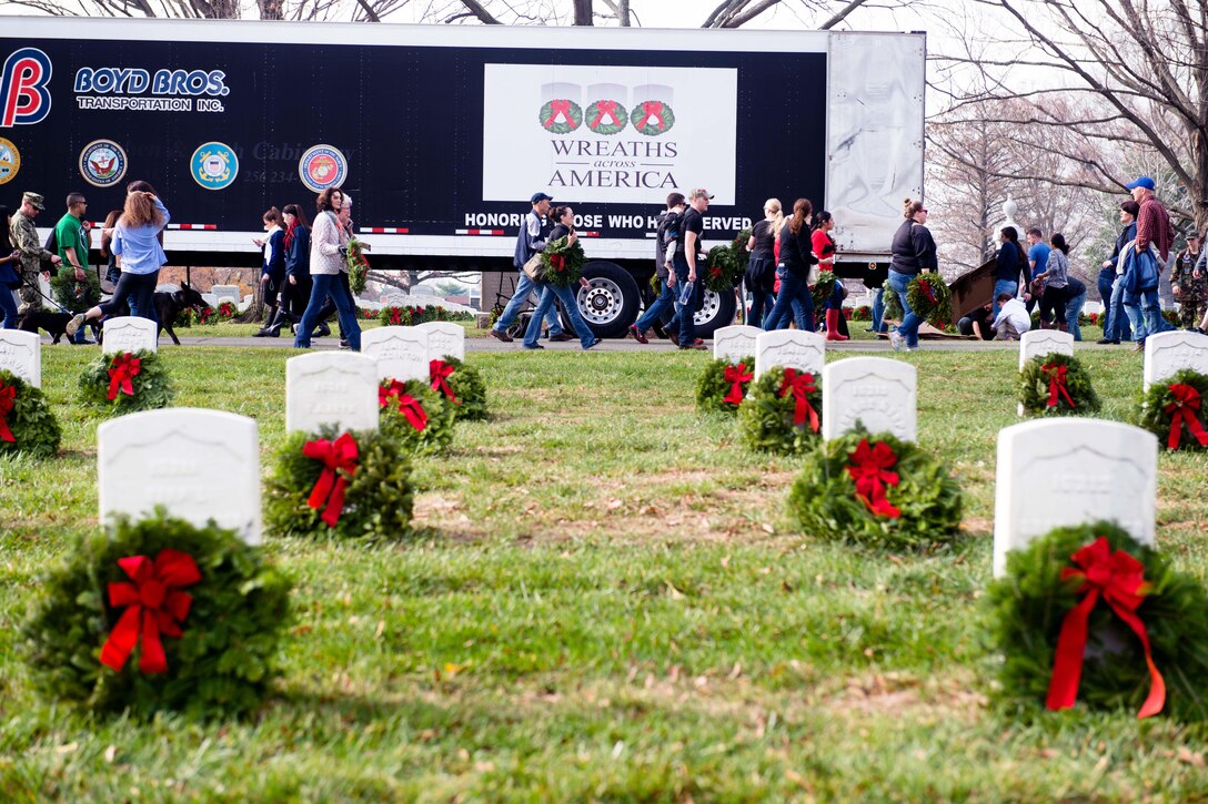 Service members and volunteers carry wreaths to be placed on grave markers during the annual Wreaths Across America event in Arlington National Cemetery in Arlington, Va., Dec. 12, 2015. U.S. Army photo by Rachel Larue