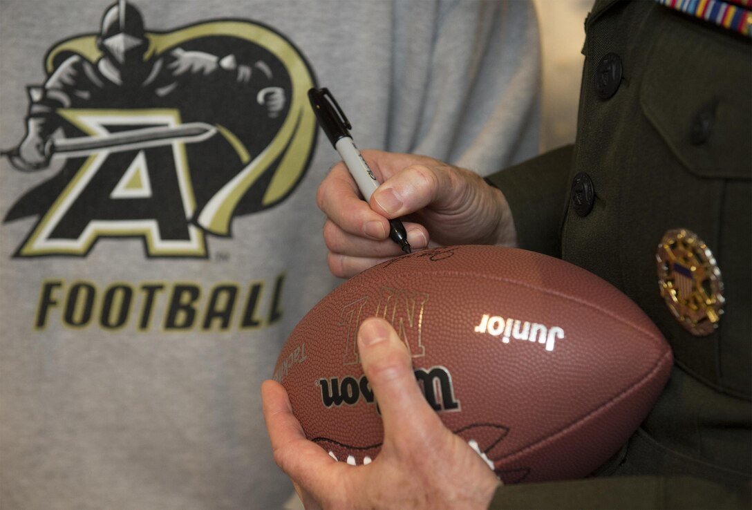 Marine Corps Gen. Joseph F. Dunford Jr., chairman of the Joint Chiefs of Staff, signs a football during the 116th Army-Navy football game in Philadelphia, Dec. 12, 2015. DoD photo by Navy Petty Officer 2nd Class Dominique A. Pineiro