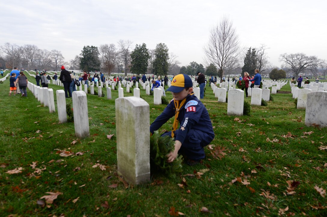 Max Brooke, a member of Cub Scout Pack 665, McLean, Va., places a wreath on a grave marker during the annual Wreaths Across America event at Arlington National Cemetery in Arlington, Va., Dec. 12, 2015. DoD photo by Sebastian Sciotti Jr.
