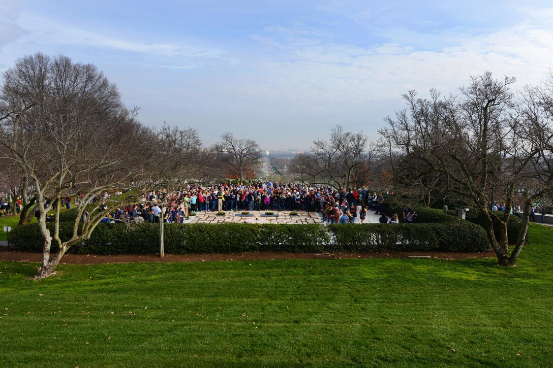 Service members and volunteers share a moment of silence after wreaths had been placed at the grave markers of the late president John F. Kennedy, Jacqueline Kennedy and children during the annual Wreaths Across America event at Arlington National Cemetery, Arlington, Va., Dec. 12, 2015. DoD photo by Sebastian Sciotti Jr.