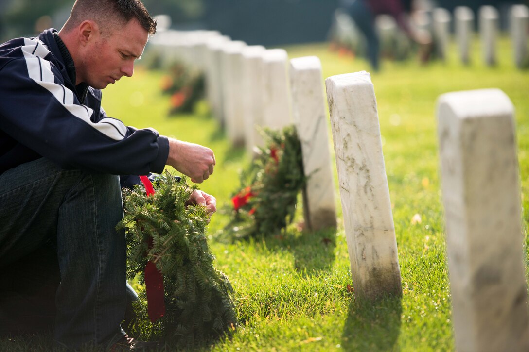 Air Force Tech. Sgt. Martin Walcott places a wreath on a grave marker during the annual Wreaths Across America event in Arlington National Cemetery in Arlington, Va., Dec. 12, 2015. U.S. Army photo by Rachel Larue