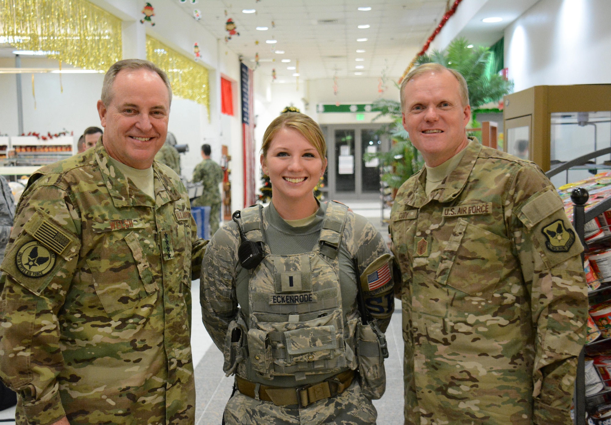 Gen. Mark Welsh III, Chief of Staff of the Air Force (left), poses for a picture with 1st Lt. Meghan Eckenrode, 379th Expeditionary Security Forces Squadron (center) and Chief Master Sgt. of the Air Force, James Cody (right), in the Blatchford-Preston Complex Dining Facility at Al Udeid Air Base, Qatar Dec. 11. Welsh and Cody met with Airmen during their visit to AUAB and thanked them for their service. (U.S. Air Force photo by Tech. Sgt. James Hodgman/Released)