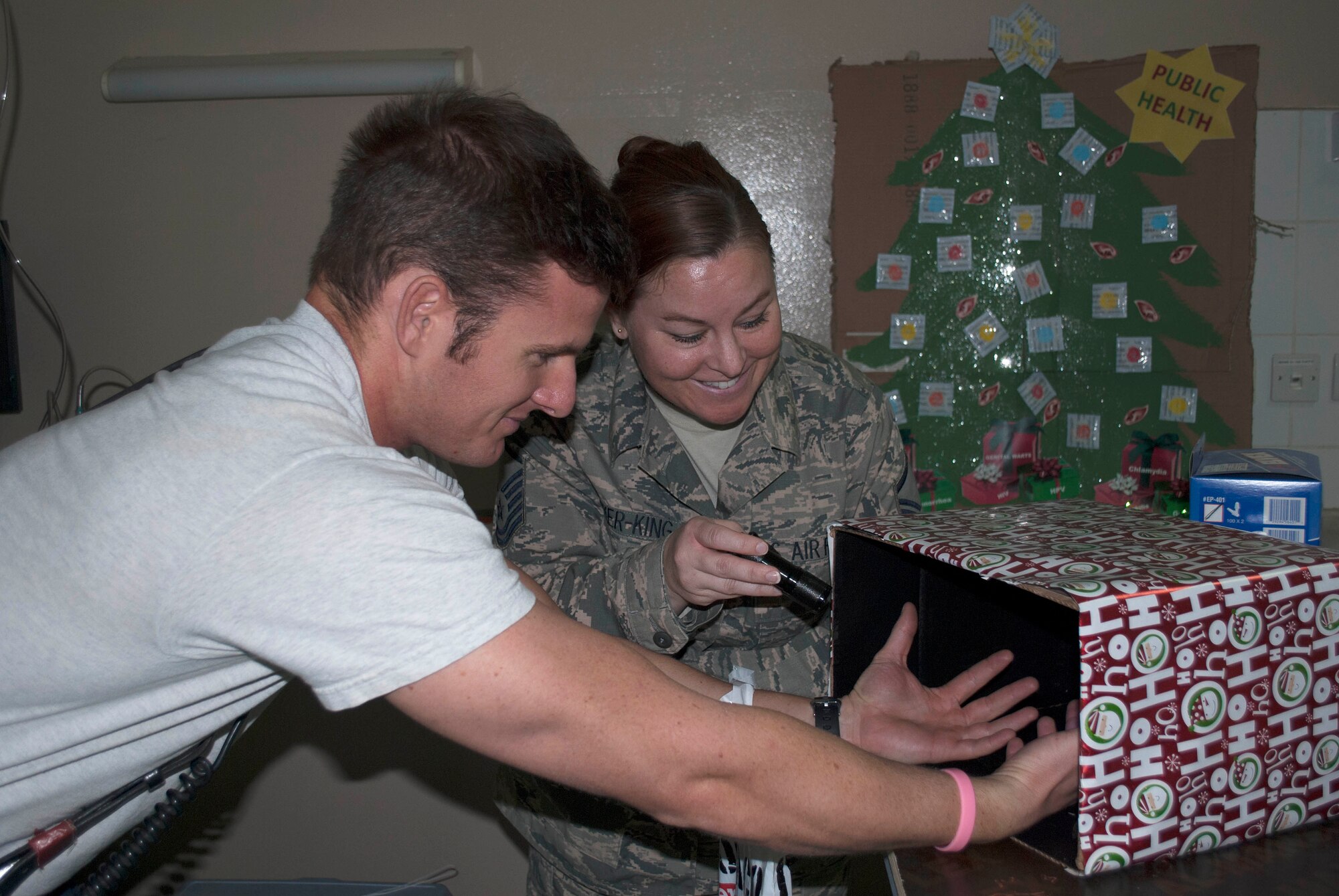 Air Force Master Sgt. Meredith Bricker-King, right, 386th Expeditionary Medical Squadron public health non-commissioned officer in-charge, educates Staff Sgt. Bradley Peyton, 386th Expeditionary Civil Engineering Squadron firefighter, on the importance of hand washing using a black light to reveal germs and bacteria on skin at an undisclosed location in Southwest Asia, Dec. 12, 2015.  The public health information booth was part of the 386th Air Expeditionary Wing’s bi-annual health fair sponsored by the 386th Expeditionary Medical Group in combination with the 386 AEW Sexual Assault Response Coordinator, Chaplain and Force Support Squadron.   Information booths focused on the three pillars of health and wellness - Mental, Physical, and Spiritual.  (U.S. Air Force photo by Maj. John Stamm)