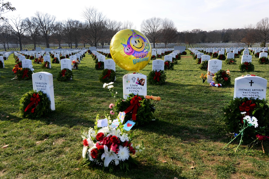 A wreath, decorated with flowers and birthday ornaments, is placed at a grave marker during the annual Wreaths Across America event at Arlington National Cemetery in Arlington, Va., Dec. 12, 2015. DoD photo by Sebastian Sciotti Jr.