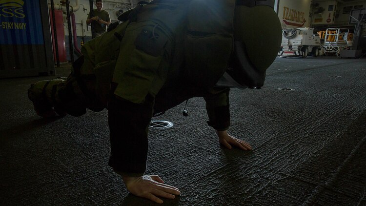 U.S. Marine Cpl. Devon J. Hornbeck, a warehouse chief with Combat Logistics Battalion 26, 26th Marine Expeditionary Unit, executes push-ups while donning an explosive ordnance disposal 9 advanced bomb suit during an EOD demonstration aboard the amphibious assault ship USS Kearsarge in the Arabian Gulf Dec. 12, 2015. Marines wore the suit and conducted exercises to gain familiarity with the equipment and better understand the equipment and responsibilities of EOD. The 26th MEU is embarked on the Kearsarge Amphibious Ready Group and is deployed to maintain regional security in the U.S. 5th Fleet area of operations. 