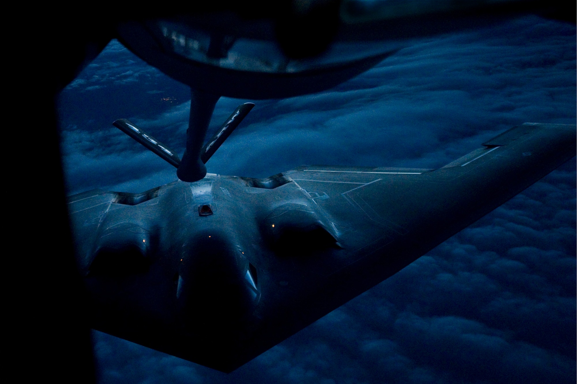 A B-2 Spirit from the 509th Bomb Wing, 13th Bomb Squadron Whiteman Air Force Base, Miss., prepares to be refueled by a KC-135R Stratotanker from the 434th Air Refueling Wing at Grissom Air Reserve Base, Ind. during a nighttime aerial refueling mission over Southern Kansas, Oct. 21, 2015. The KC-135 has a system of exterior lights located on the belly of the aircraft, just behind the nose gear, and flood lights on the boom pod used to pass fuel to the receiver aircraft during low-light conditions.
