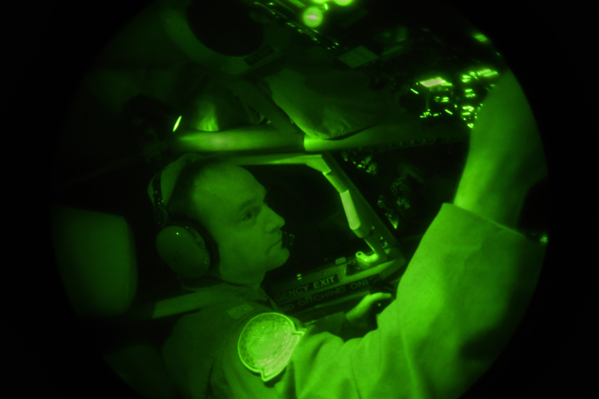 Lt. Col. Rich Day, 74th Air Refueling Squadron pilot, operates the controls of a 434th Air Refueling Wing KC-135R Stratotanker during a nighttime aerial refueling mission over Southern Kansas, Oct. 21, 2015. Pilots rely on illuminated instruments that appear green in the photo due to the use of a night-vision lens. (U.S. Air Force photo/Tech. Sgt. Benjamin Mota)
